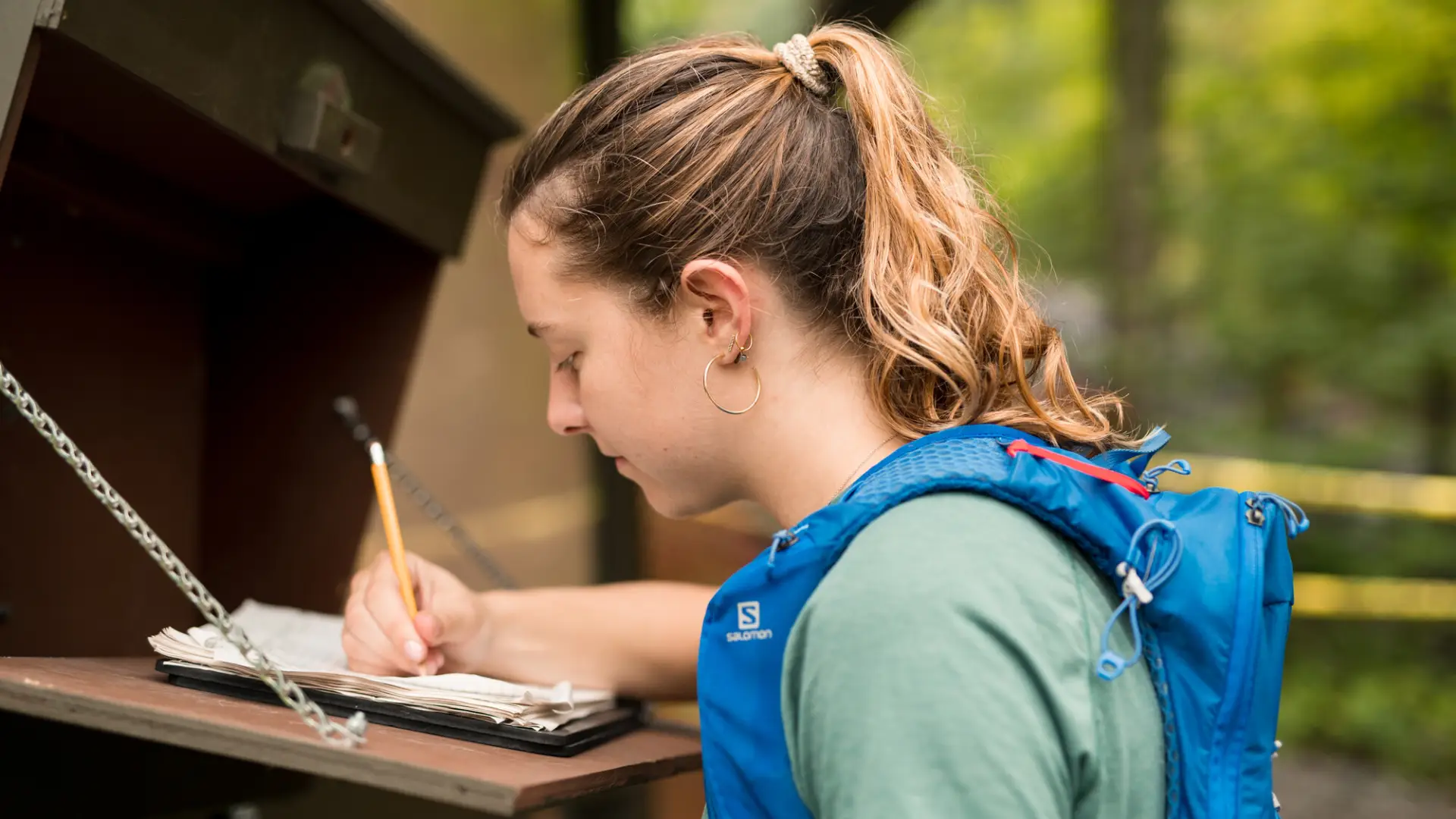 A woman signs in to a trail.