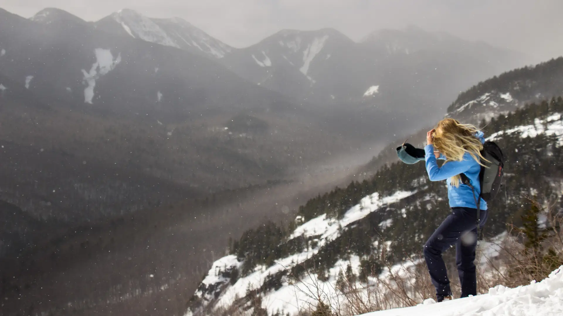 A winter hiker on a cliff of the Three Brothers