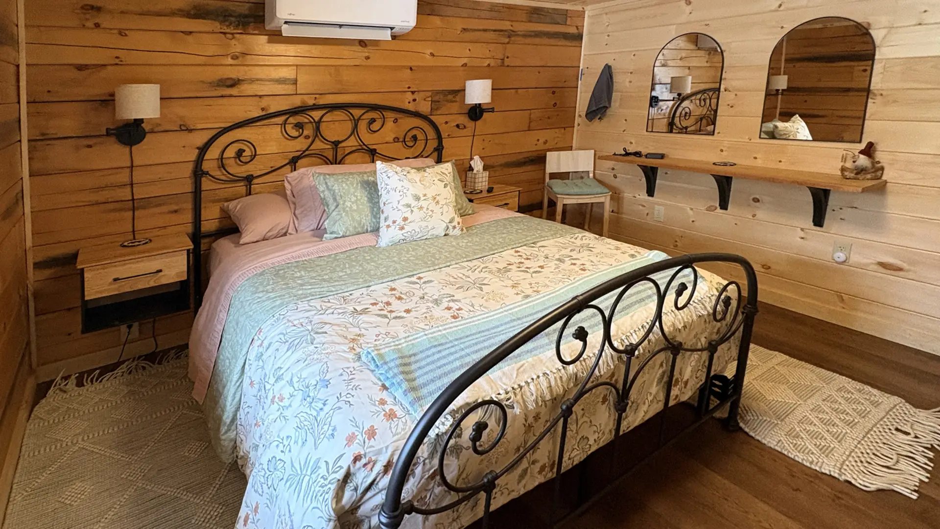 A black frame bed in a wood panel walled room.
