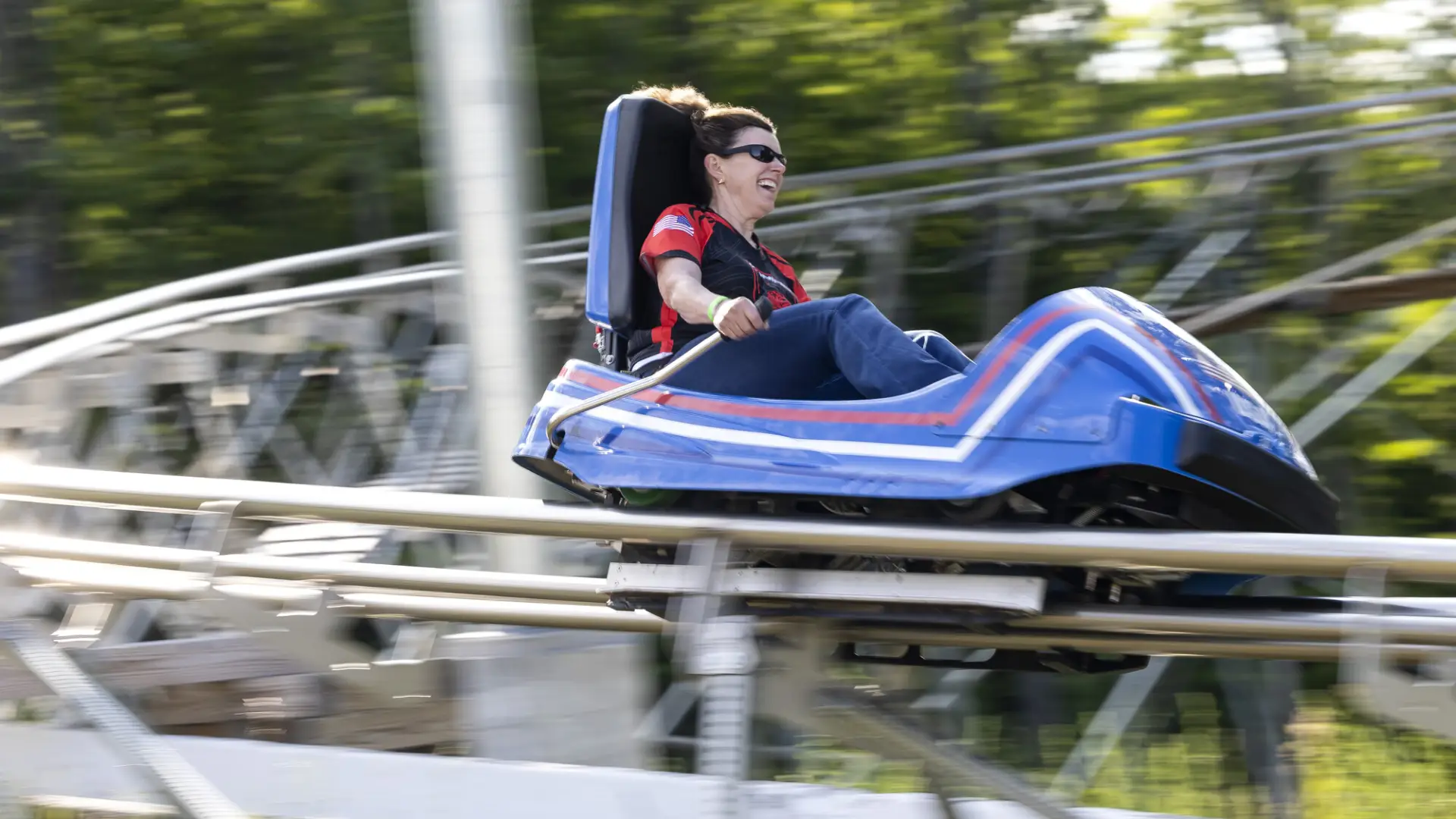 A woman speeds down a rollercoaster track in a cart.