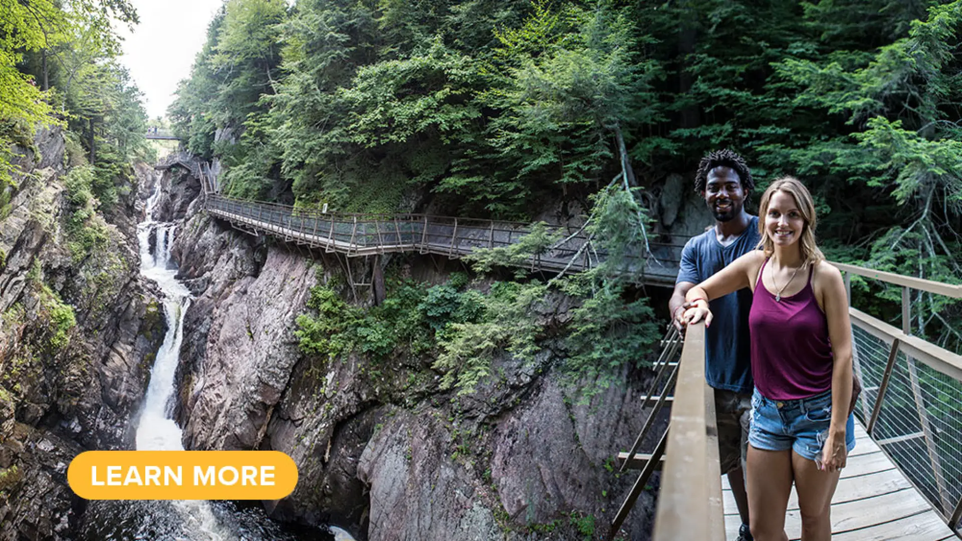 A couple poses on a footbridge crossing over High Falls Gorge.