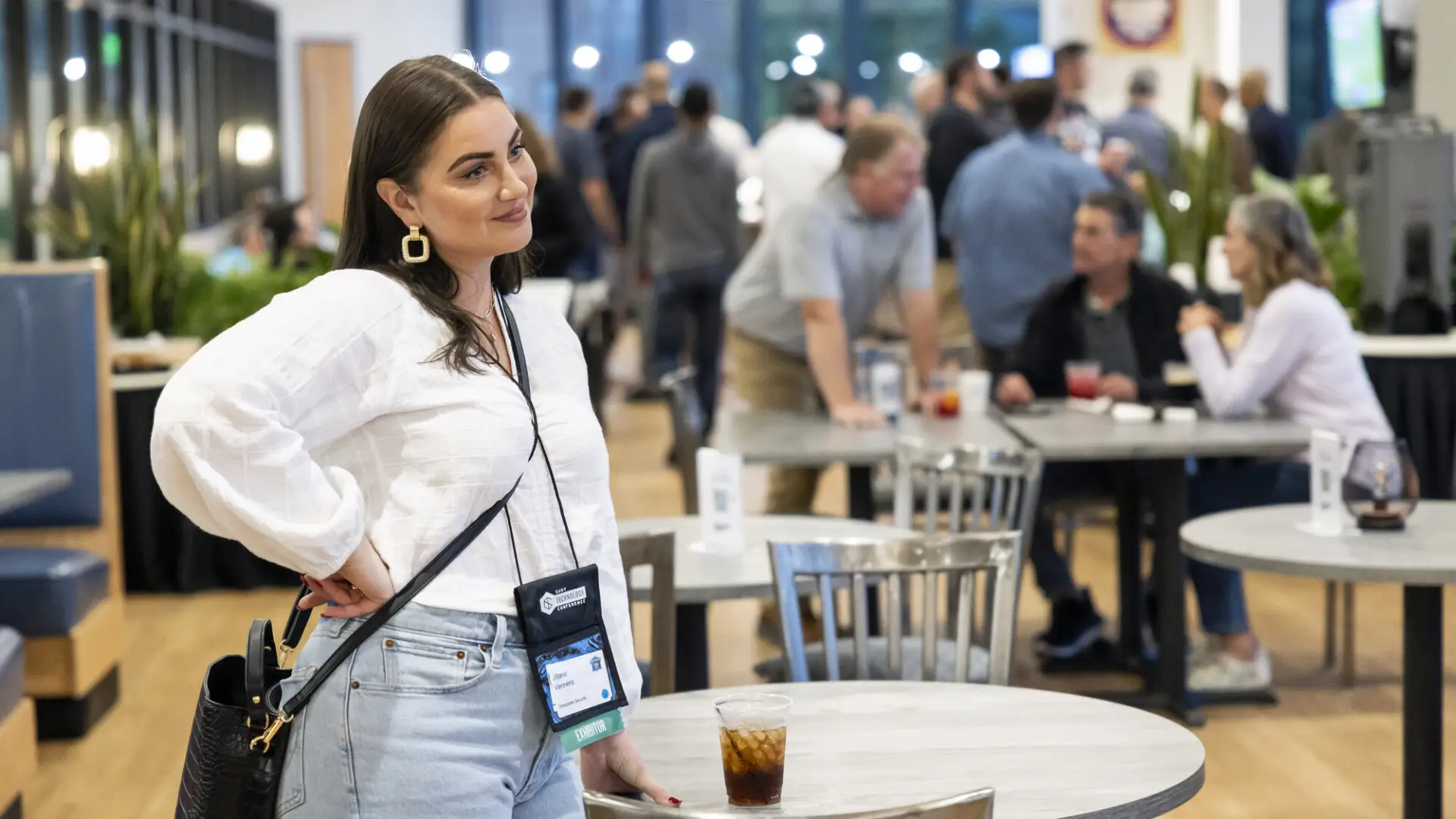 A woman smiles at a conference. 
