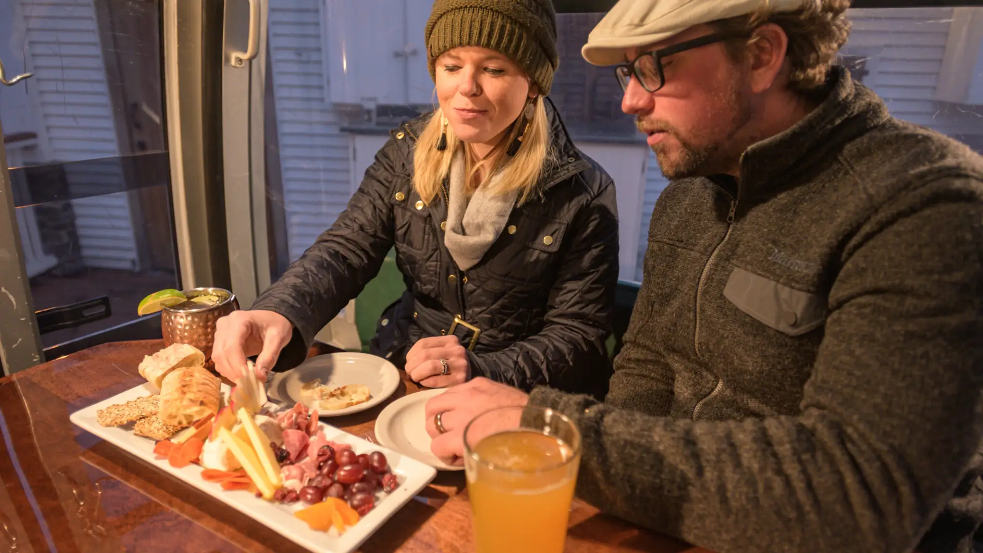 A man and woman share a charcuterie board.