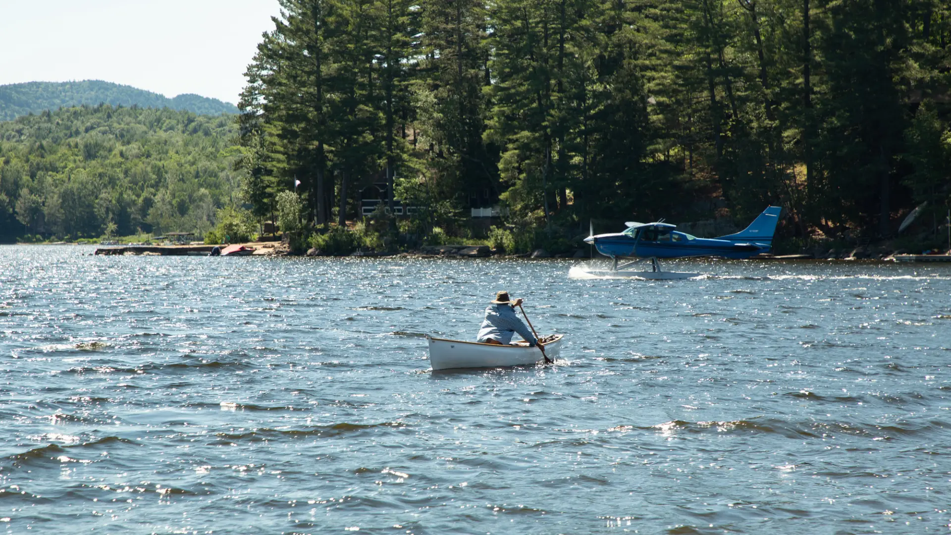A person paddles out across a lake. 