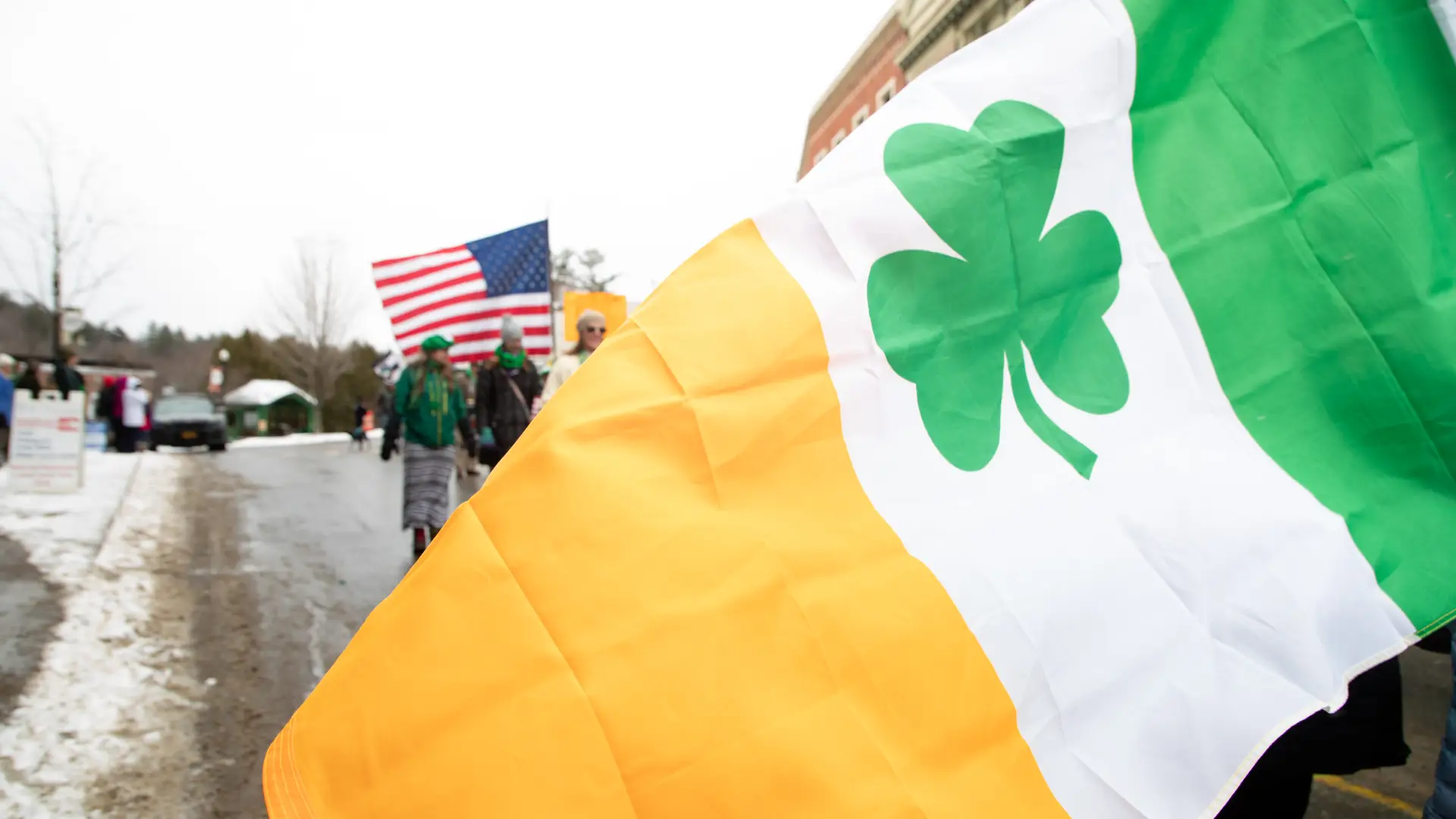 And Irish flag with a clover flown in front of an American flag