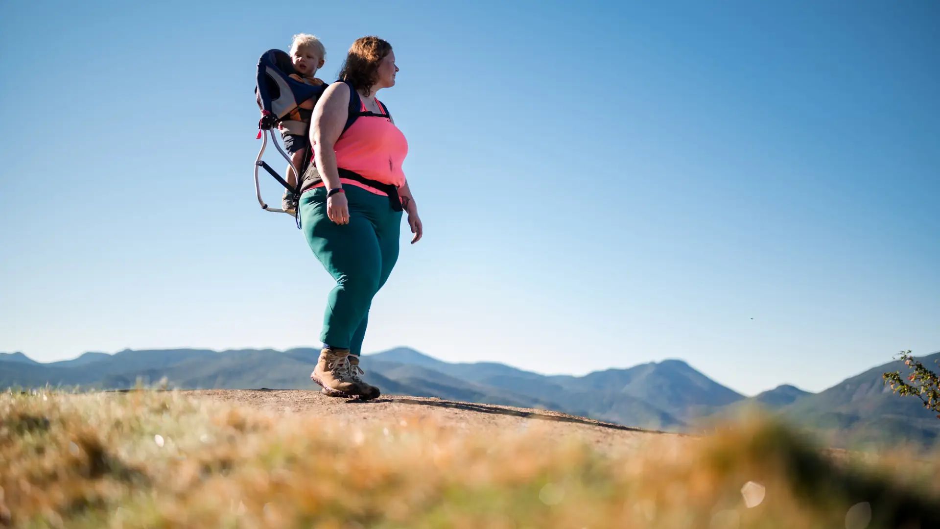 A mom hiking with her child in her backpack.