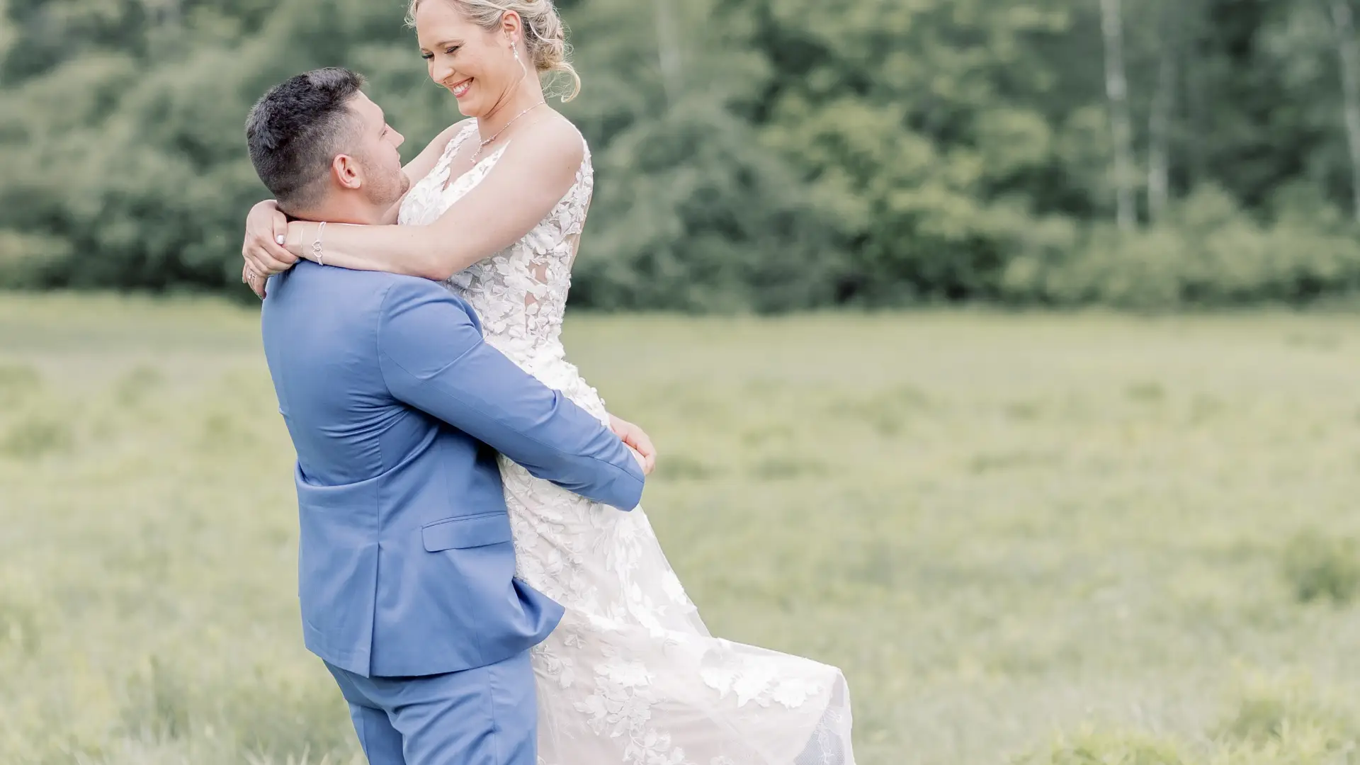 Groom holds bride in the air and spins