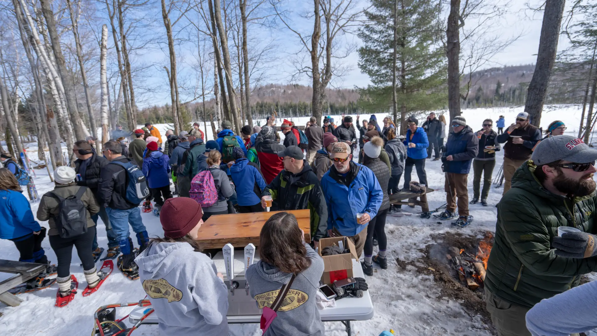Cross-country skiers getting beer along a trail. 