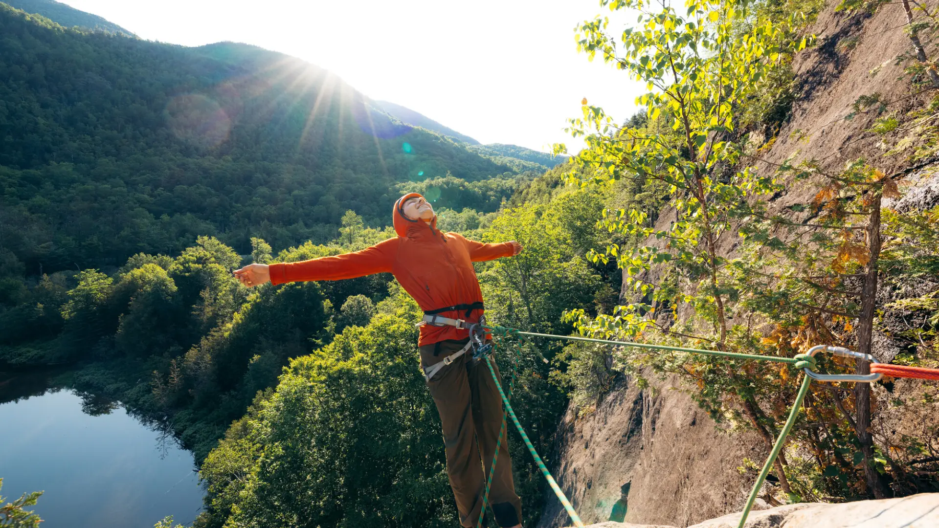 A climber celebrates with outstretched arms after a pitch