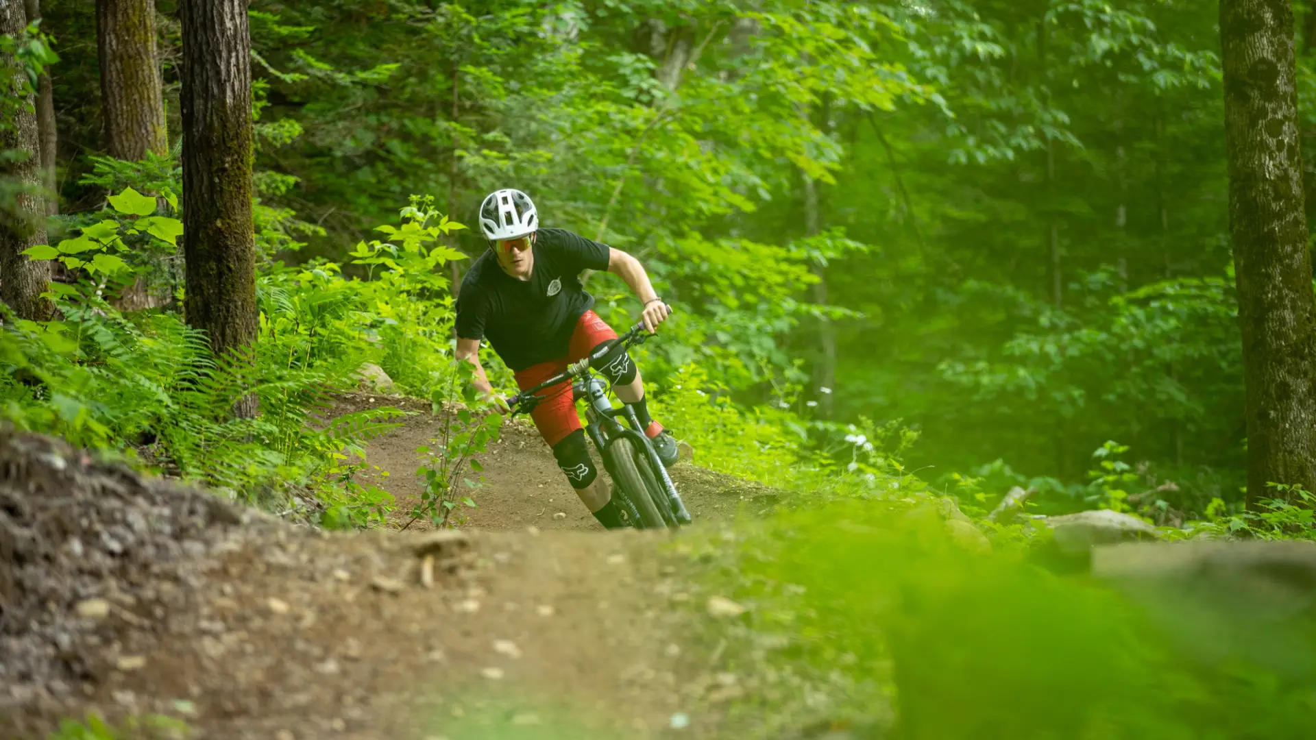 A man rides his mountain bike on a trail through the woods