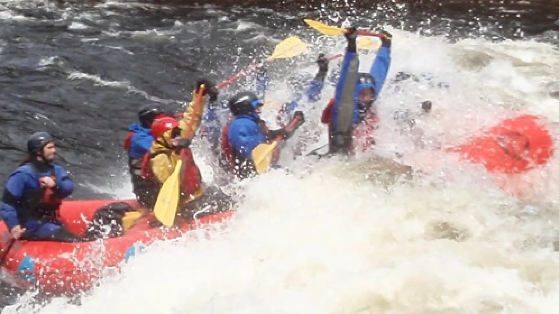 Paddles up overhead while hitting the white water