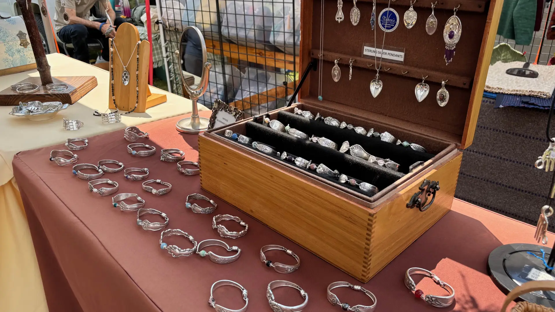 Bracelets, rings and necklaces made from old spoons are displayed in a jewelry box
