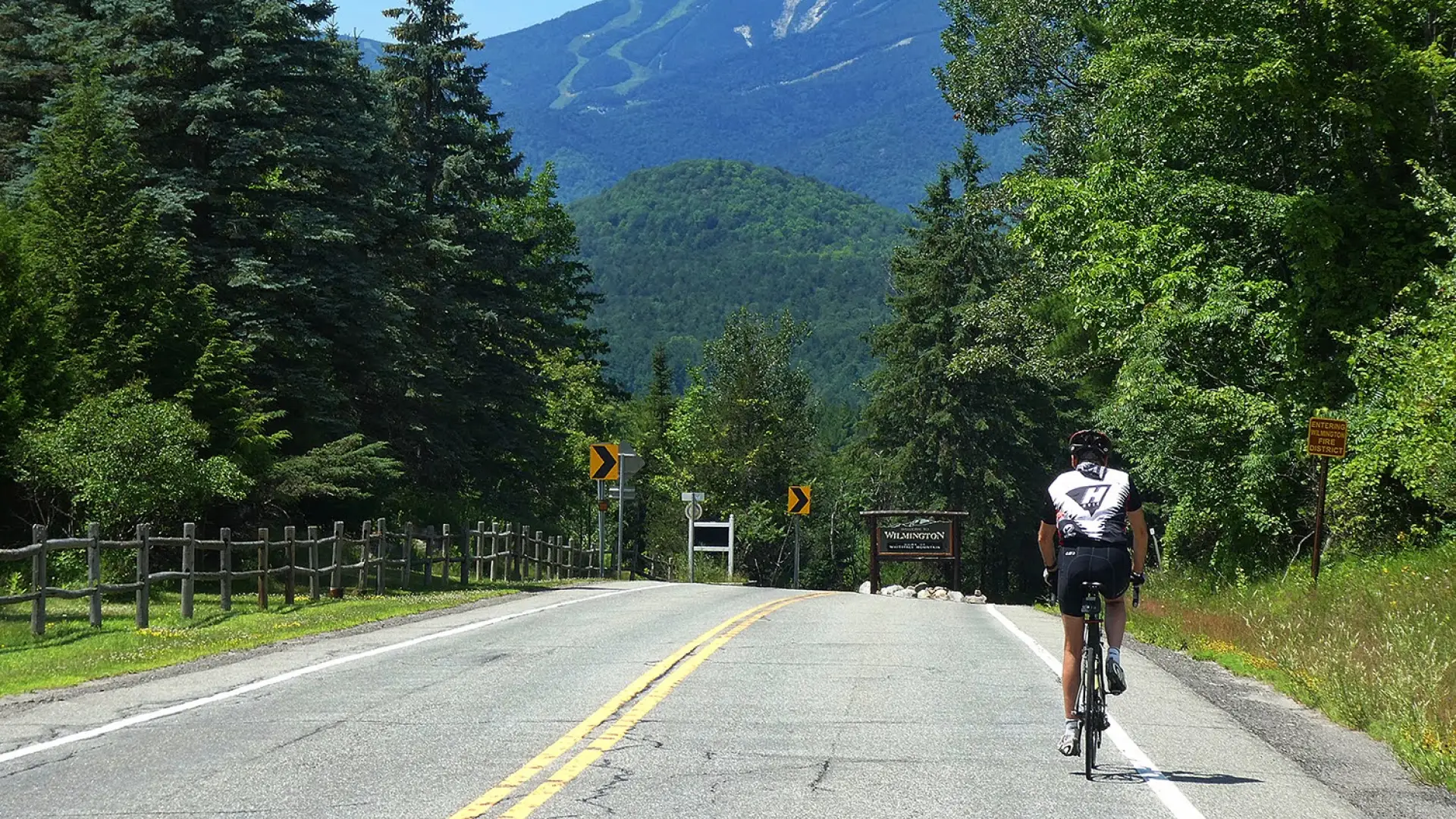 Cyclist on road with Whiteface Mountain in distance