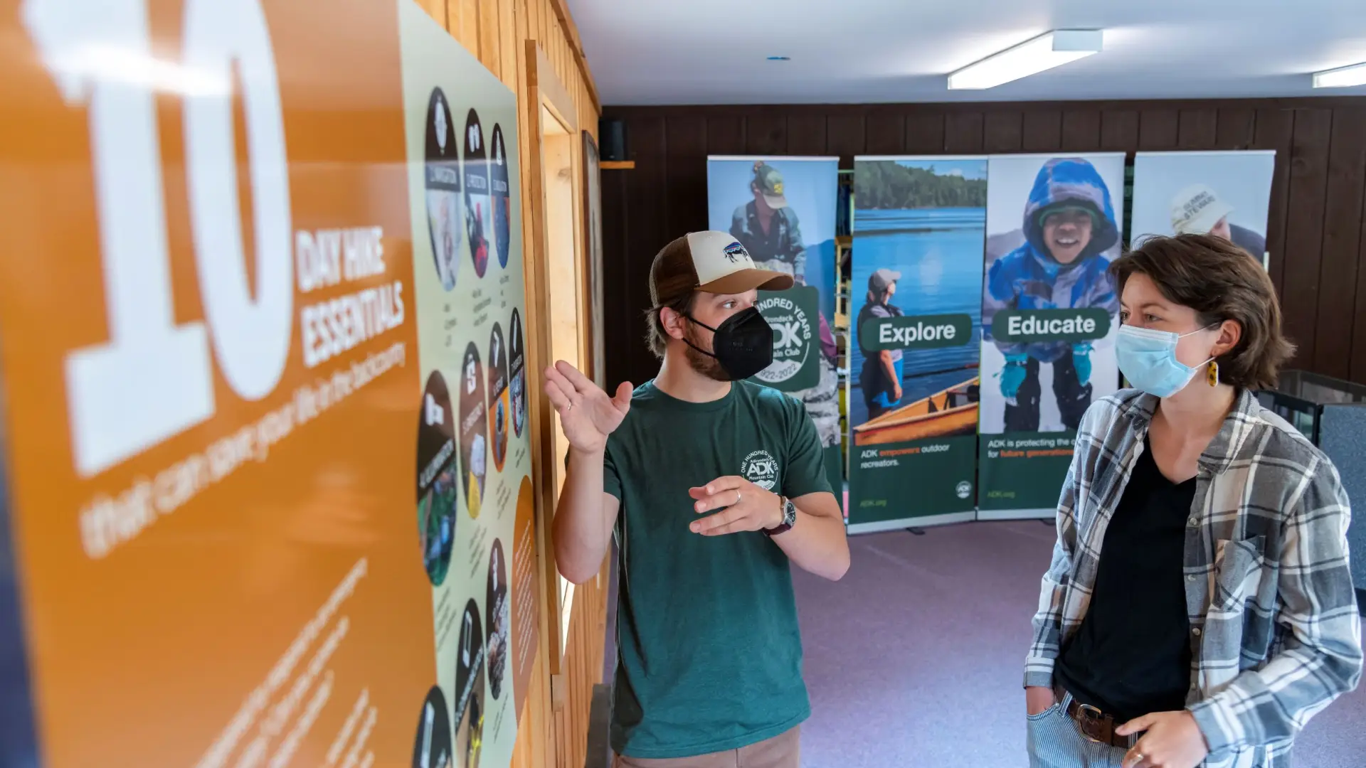 A guide helps a visitor read an information poster.