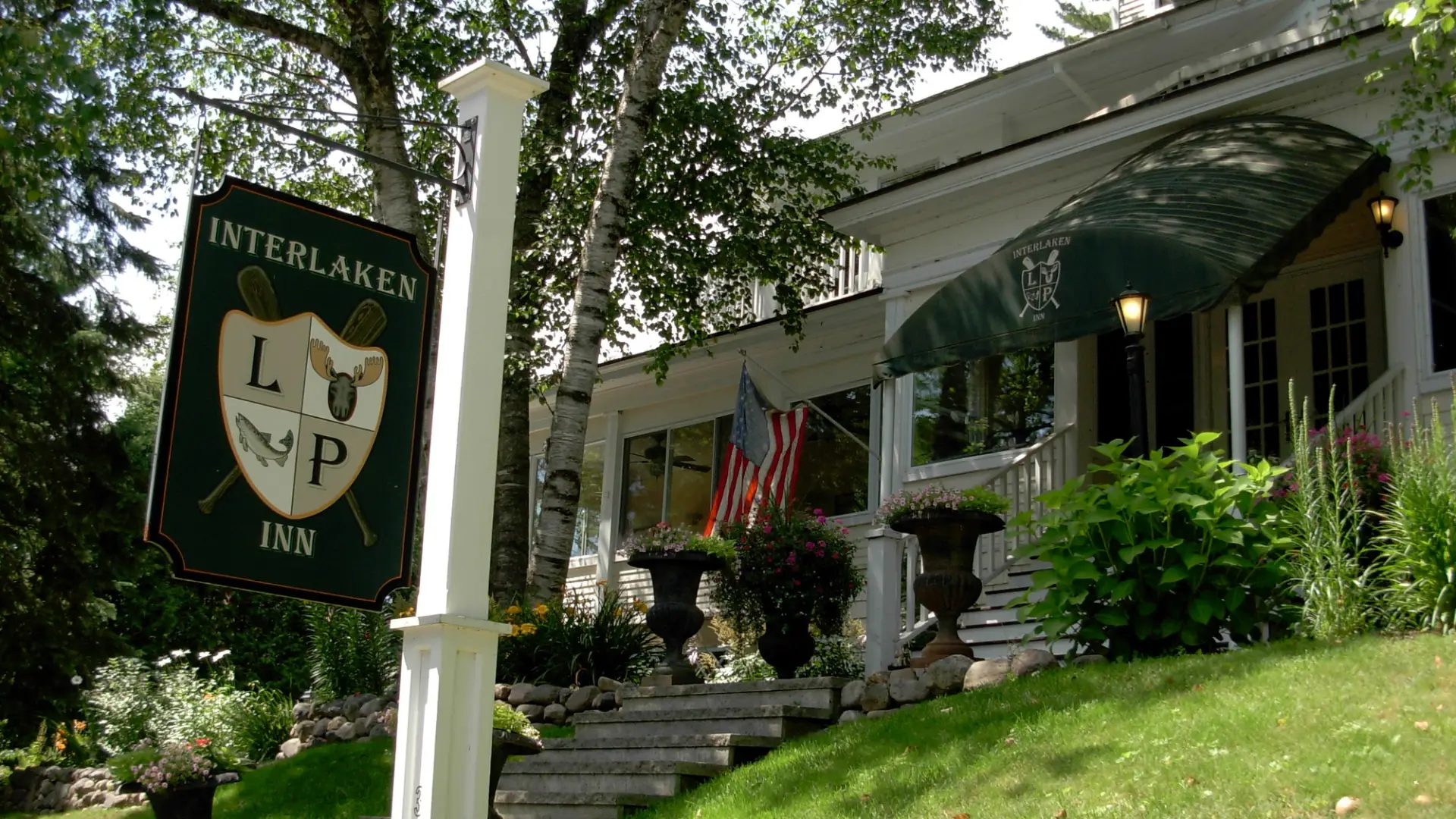 The front of a white hotel on a hill.