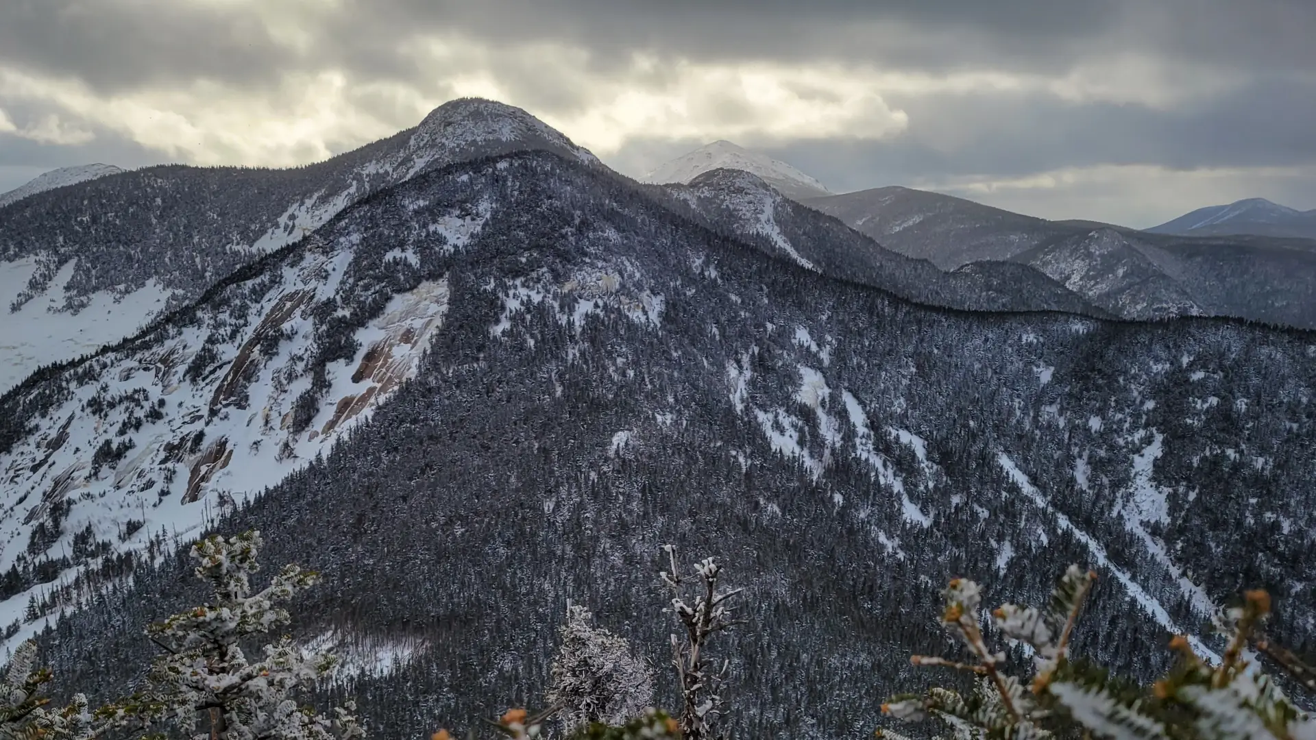 View of a tall mountain with rock slides covered in snow