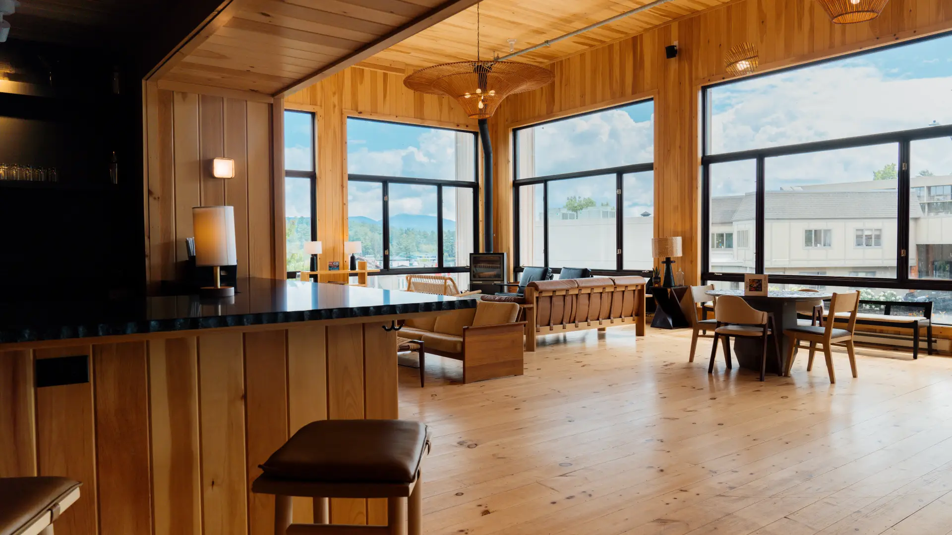 A view from the corner of the bar looking into the great room and the walls of large windows.