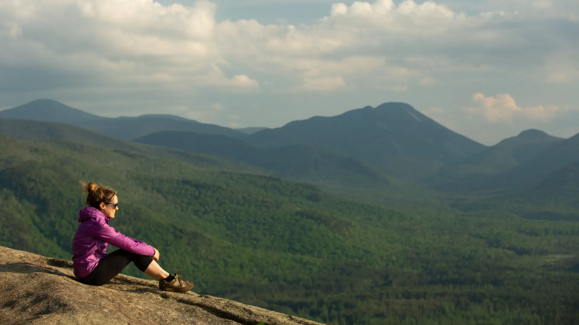 A hiker on a summit during the spring