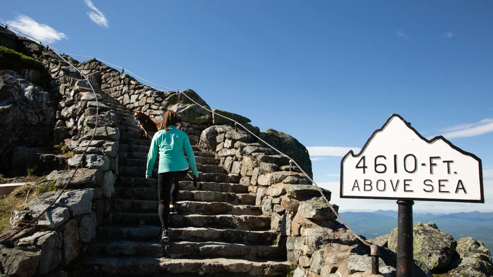 A woman walking up the stairs from the parking lot to the top of Whiteface mountain