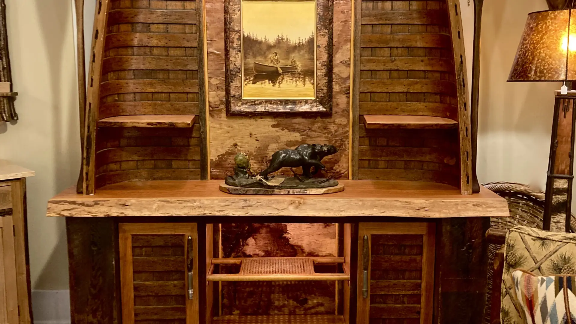A large hutch created from two wooden ribbed canoes with paddles on the sides.