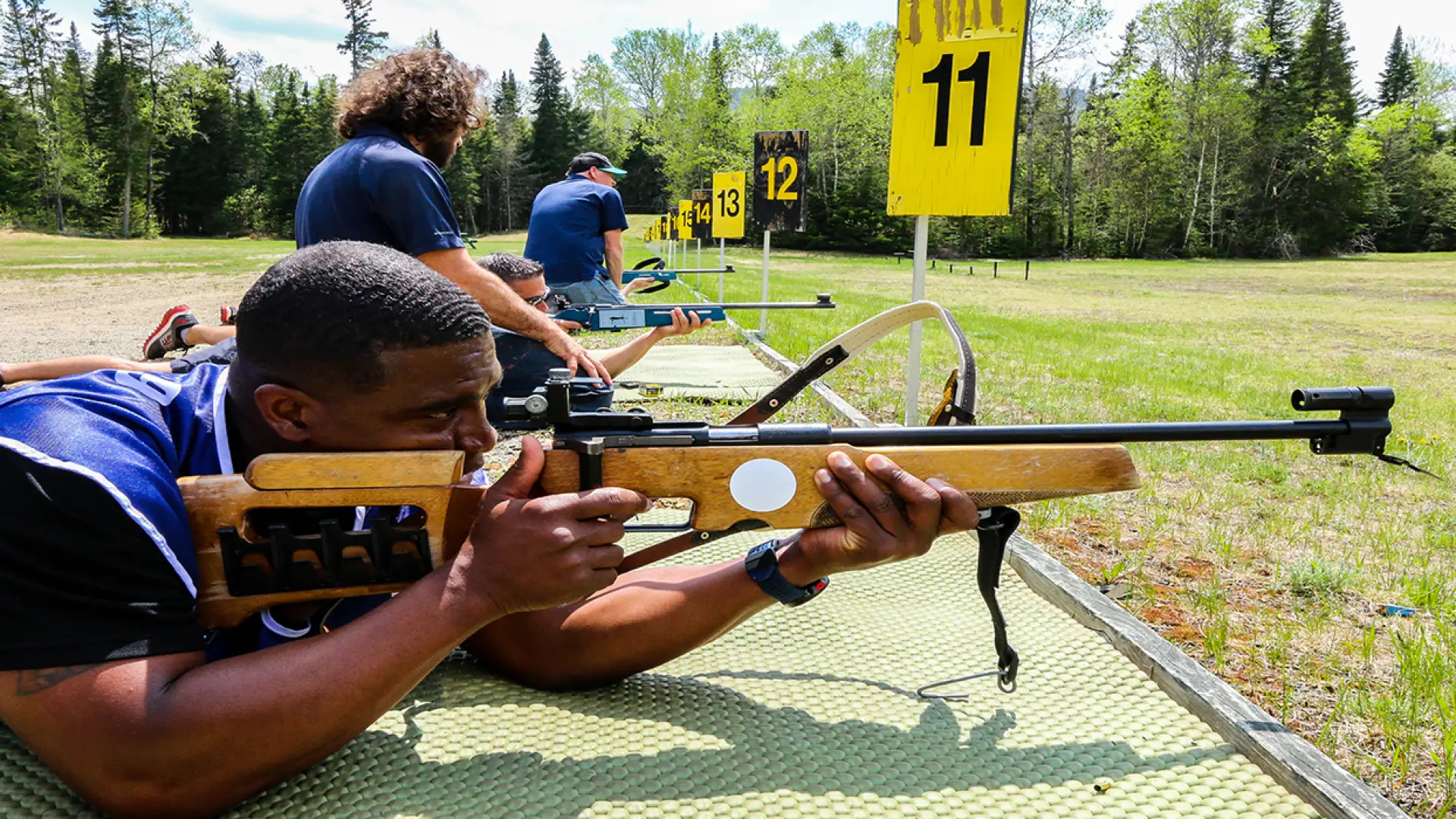 visitors trying biathlon rifles at the biathlon experience