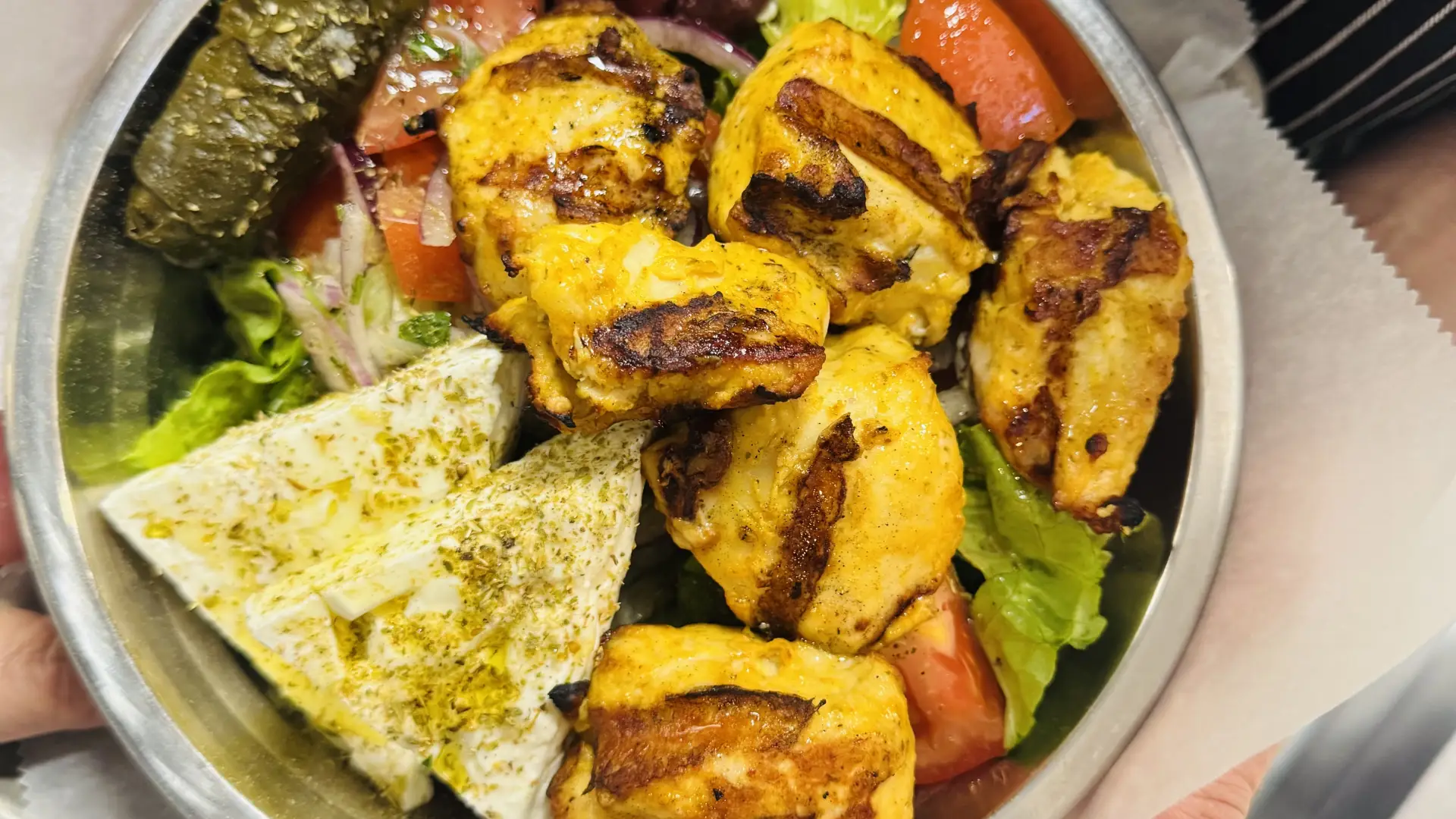 Greek salad topped with grilled chicken
