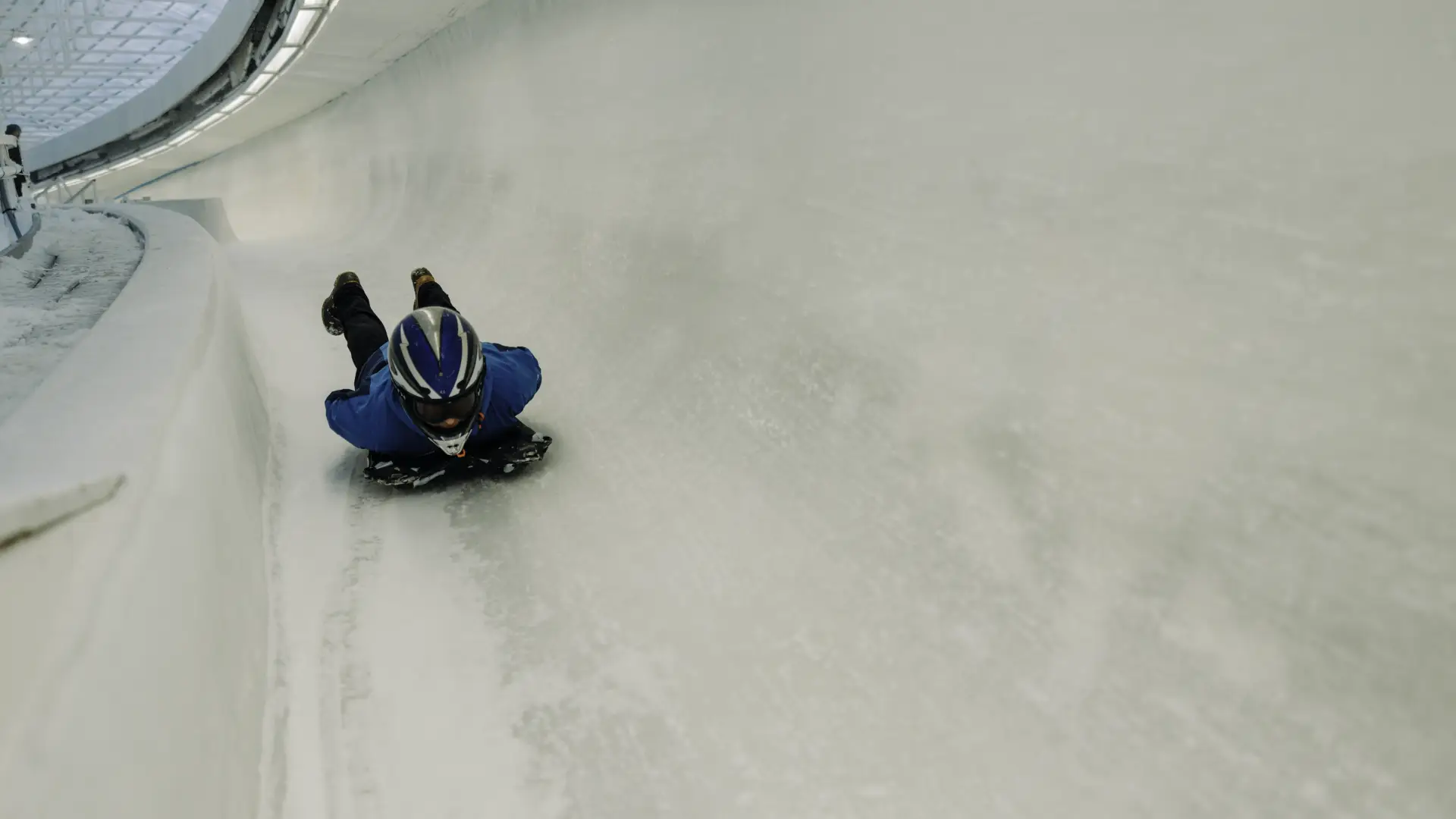 Person slides head first on a skeleton sled down an ice track