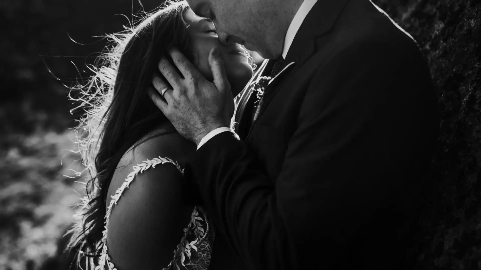 A man and his wife tenderly embrace and lean in to kiss