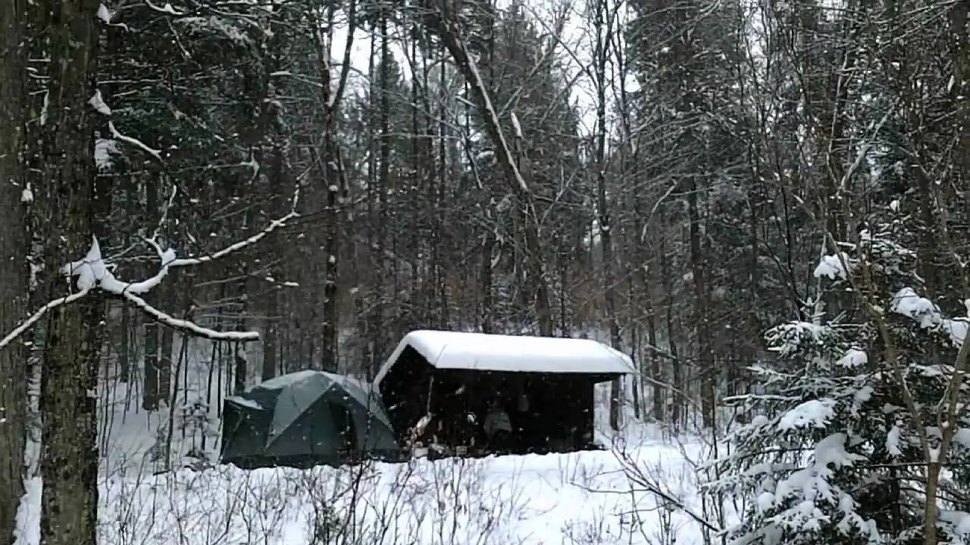 Winter camping set up by a lean to