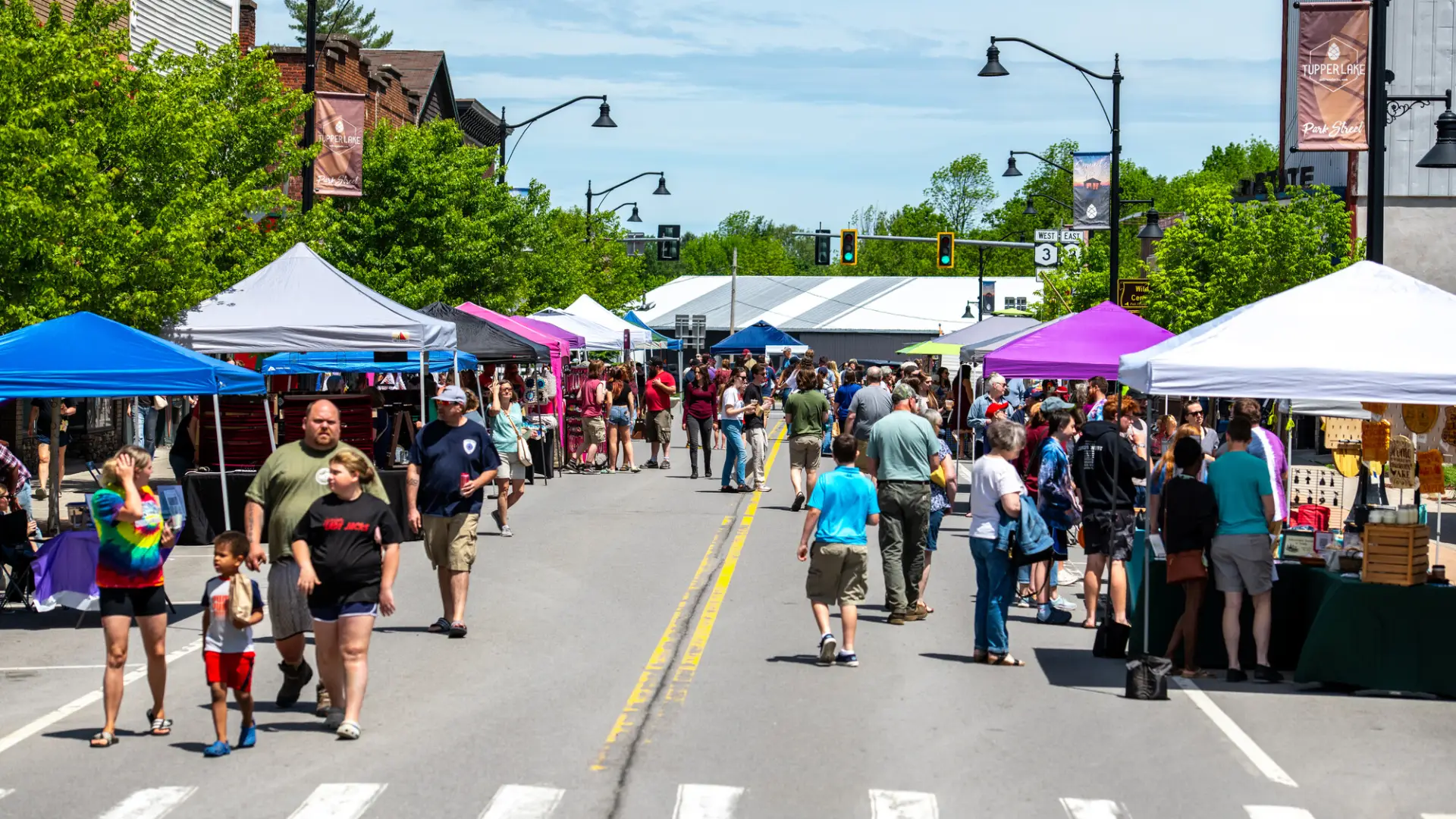 A crowd of people enjoying an event during a sunny day.