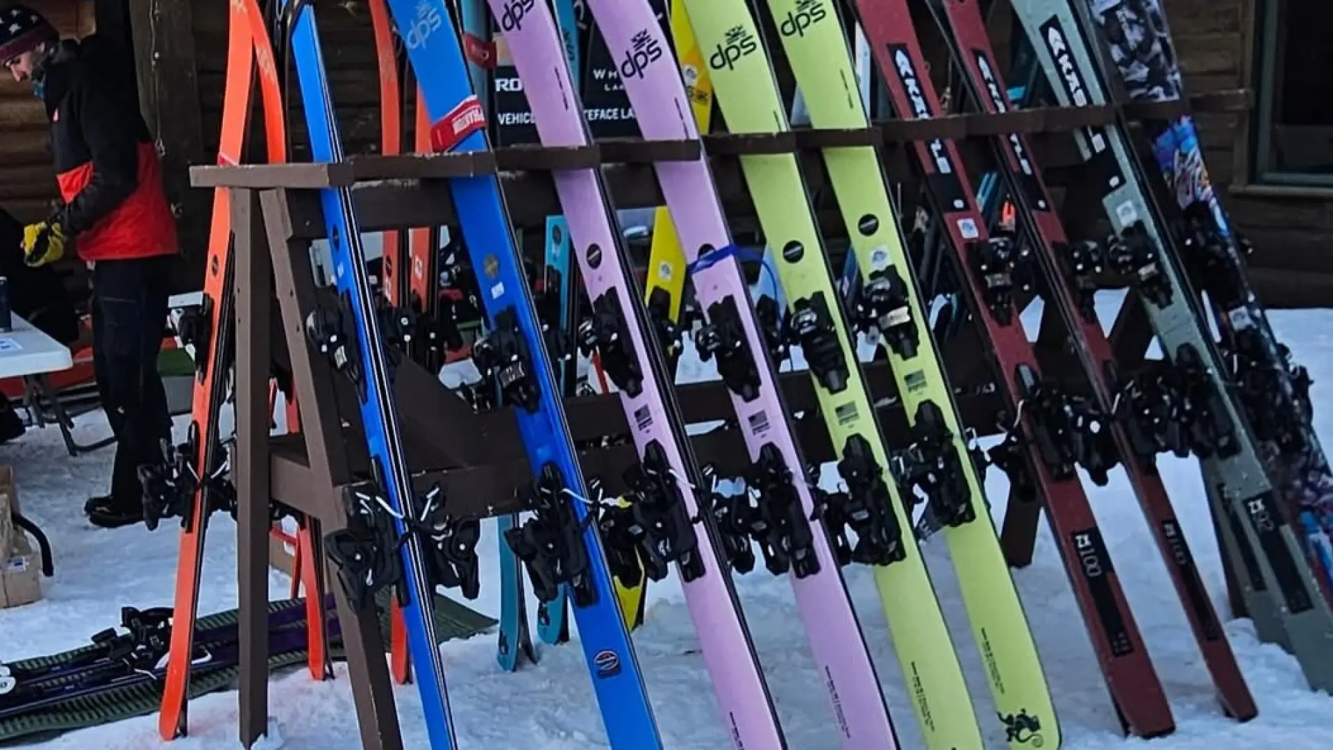 Ski rack filled with different colored skis