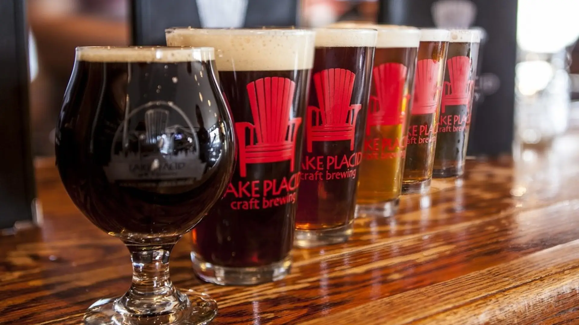 A line of glass cups with "Lake Placid Craft Brewing" printed on the side.