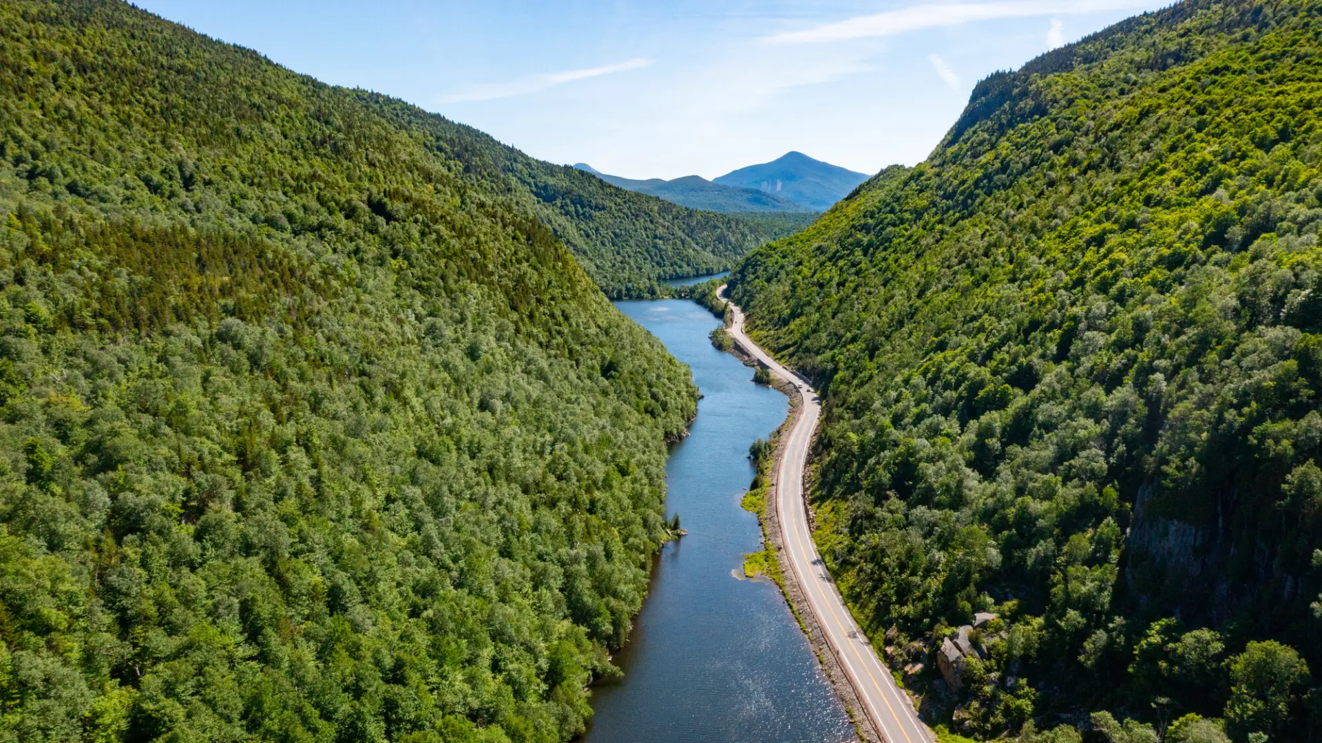 A road running through a mountain pass, adjacent to lakes