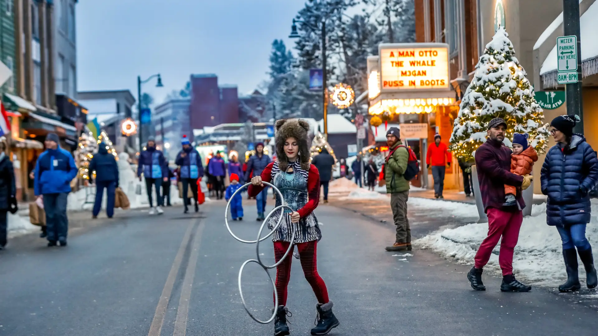 A woman dances with giant rings at a Main Street event in Lake Placid in winter. 