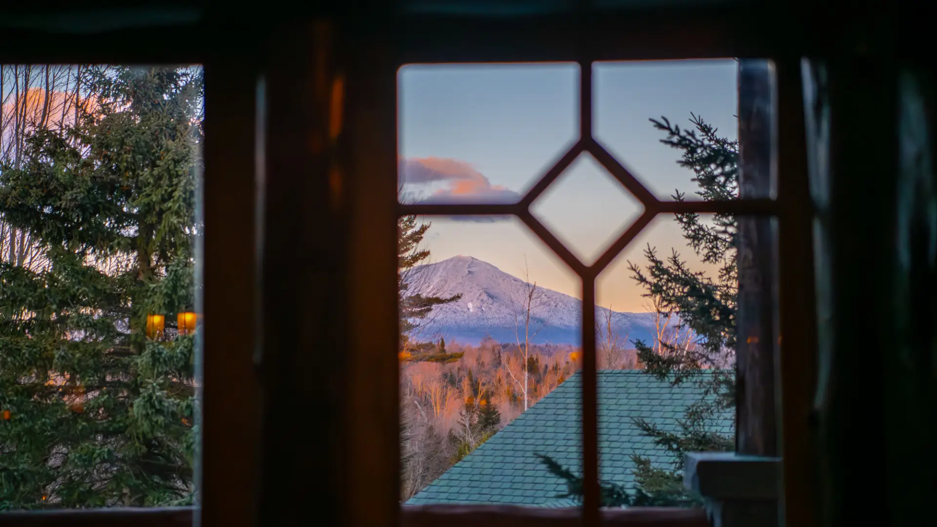 A look at a mountain from a snowy window.