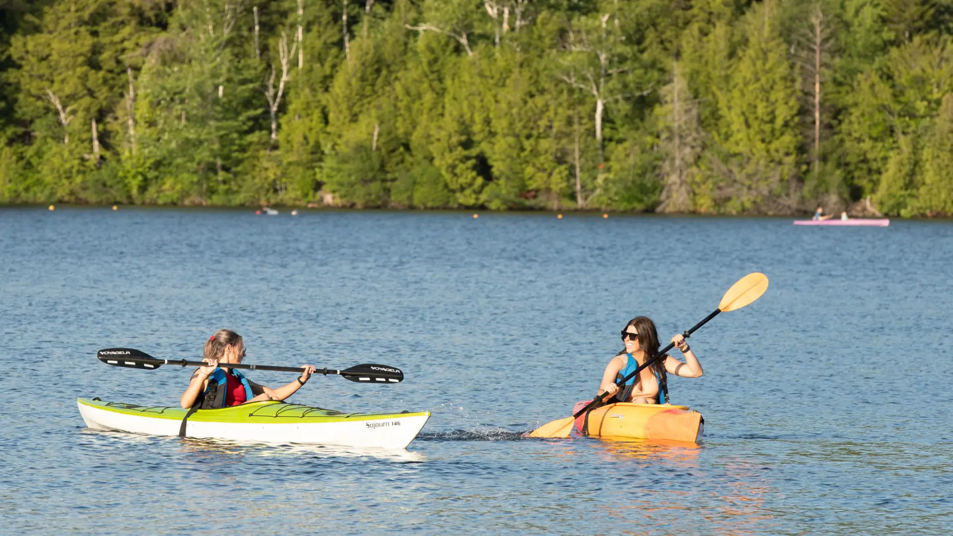 Two kayakers paddling on Mirror Lake in Lake Placid.