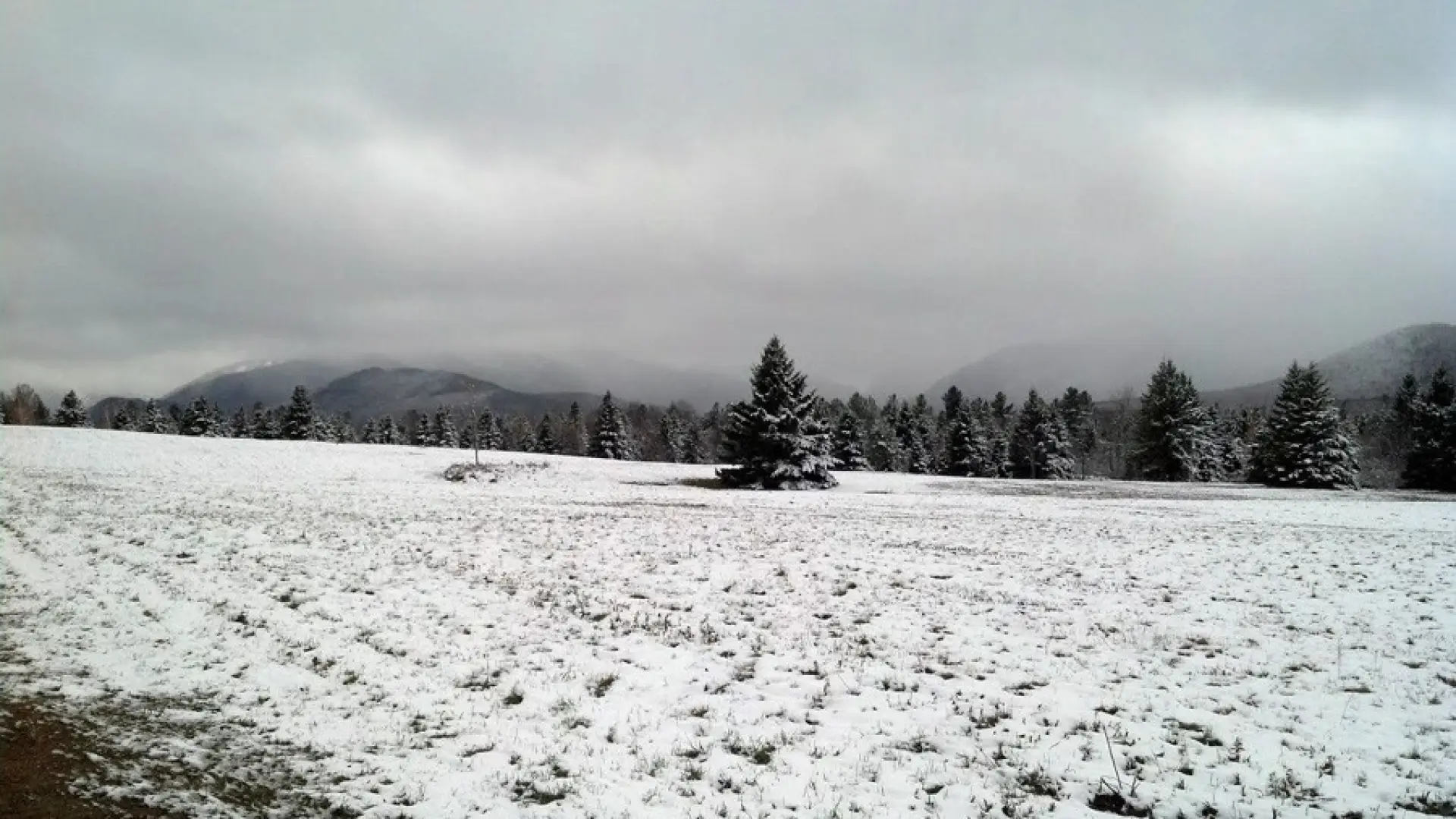 A wintry view of a field and mountains
