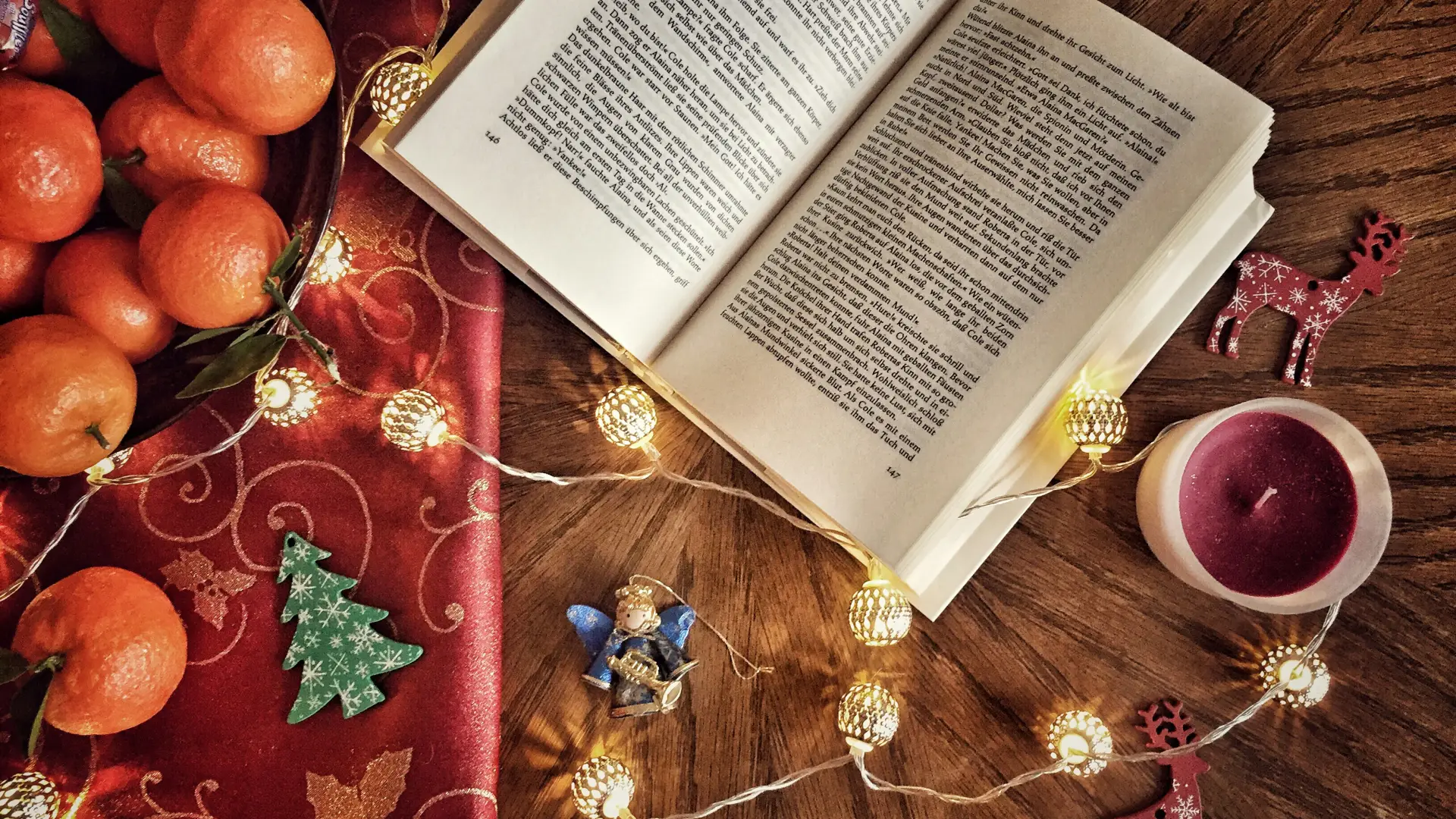 Stock photo of book open on wooden table surrounded by holiday decor