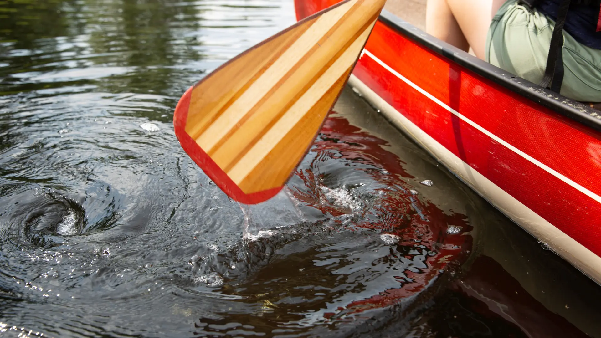 Close up of a canoe paddle in the water.