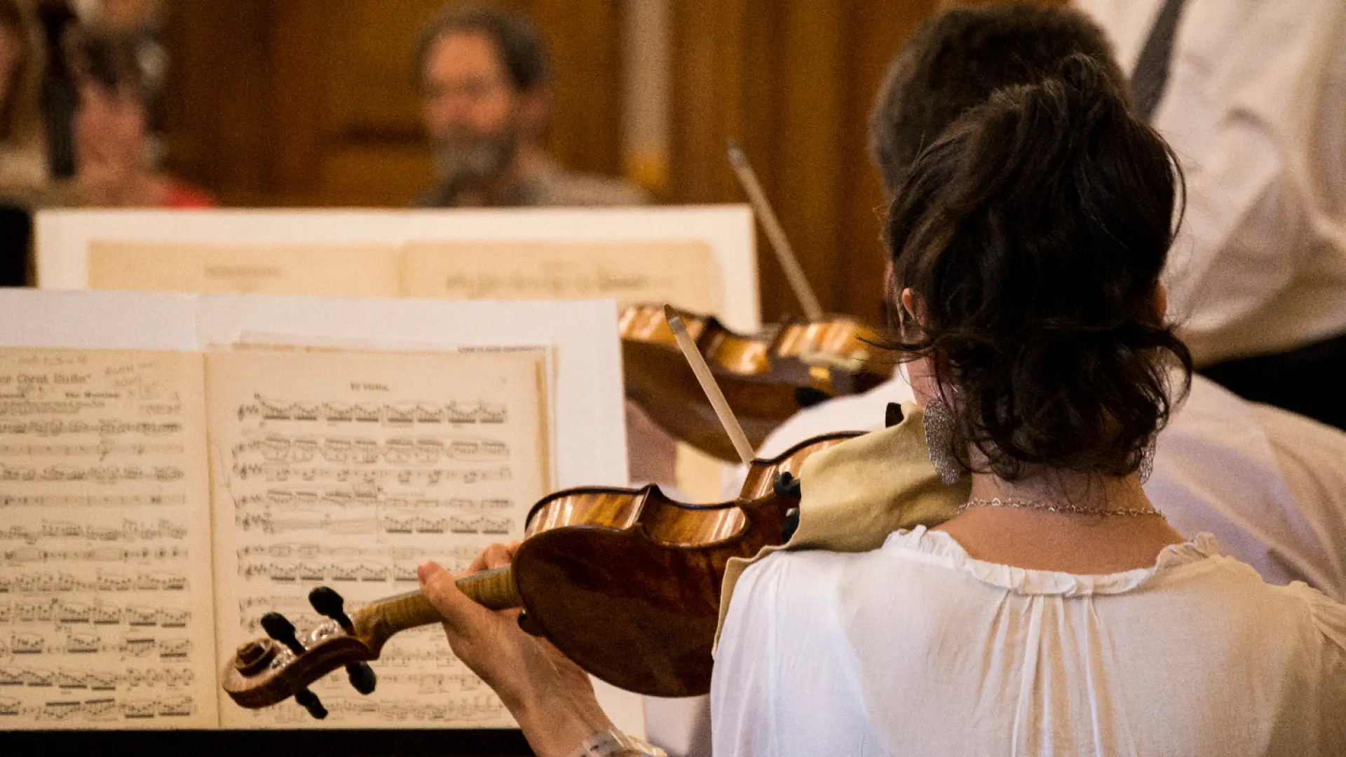 Woman reads music while playing violin