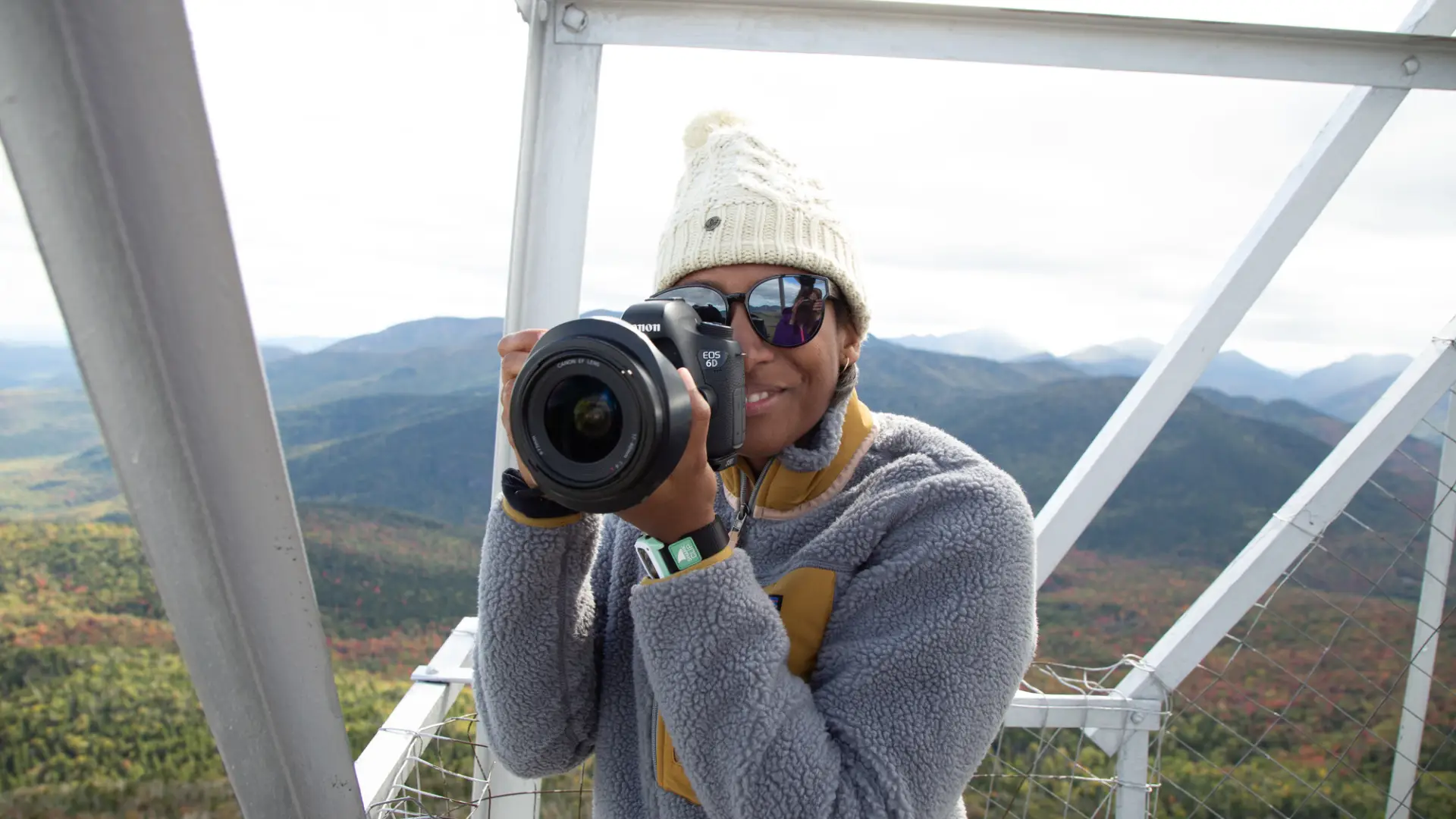 A woman takes a picture in a fire tower.