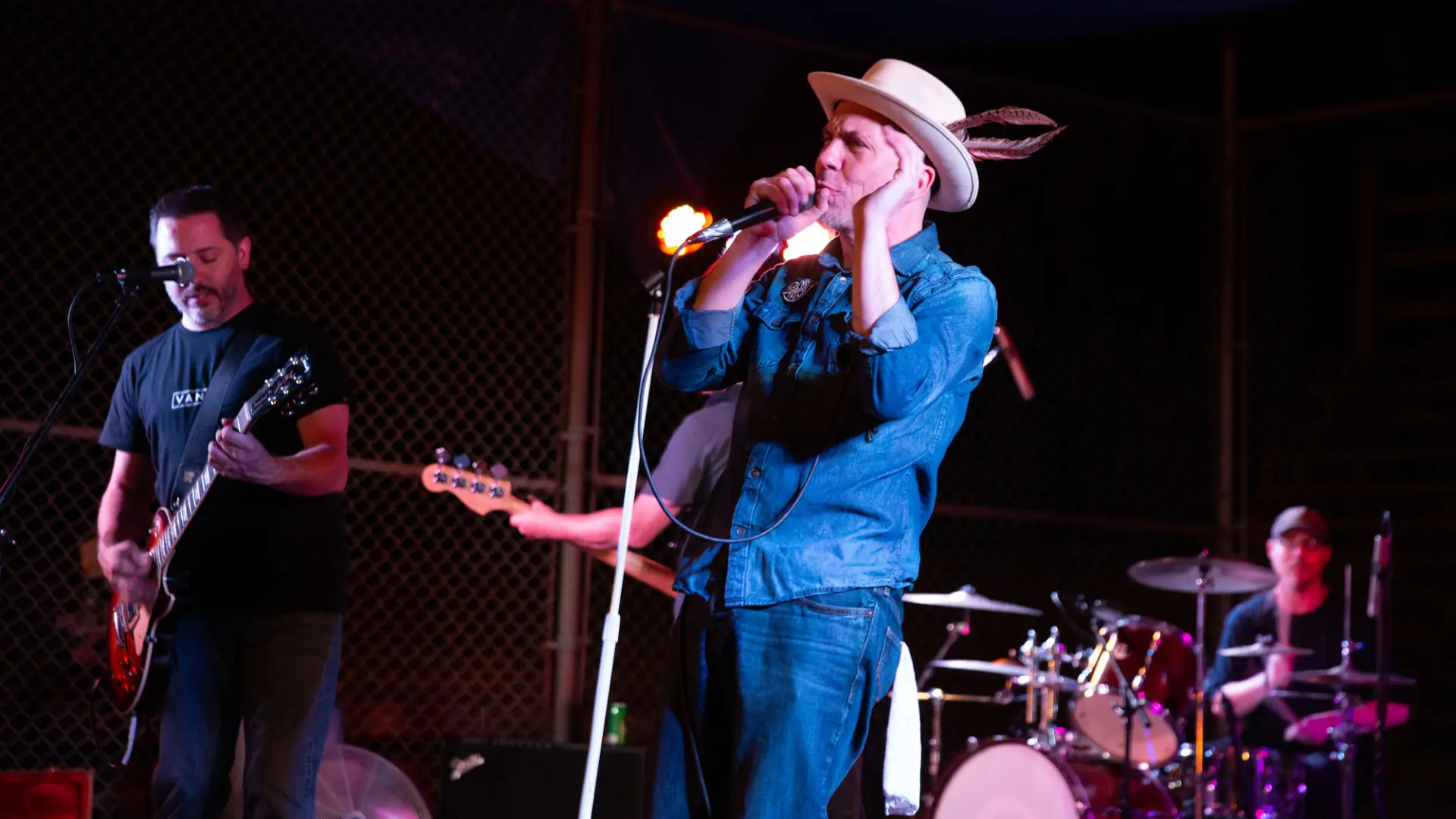 Band playing on stage with guitarist, singer and drums