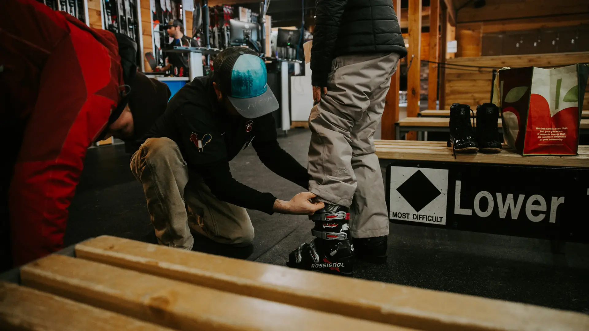 A ski tech helps someone fit a boot.