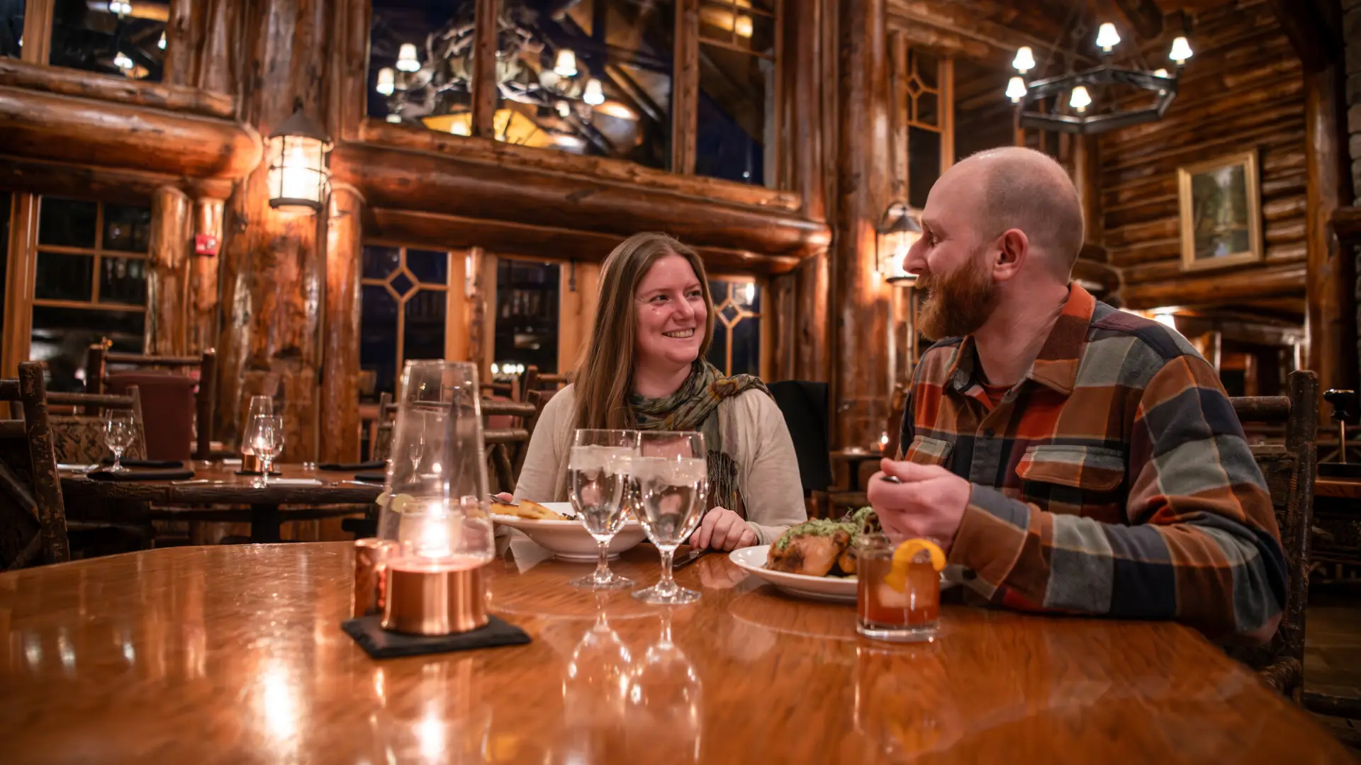 A couple dines in a grand lodge dining room.
