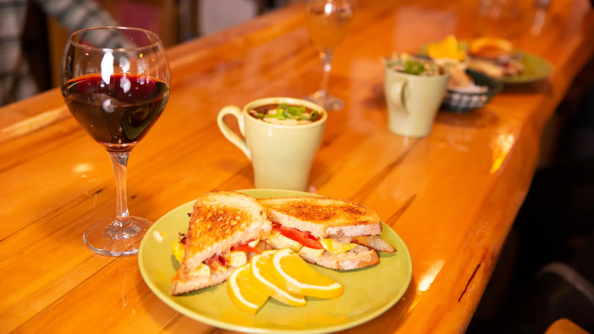 A plate of food and glass of wine on a bar