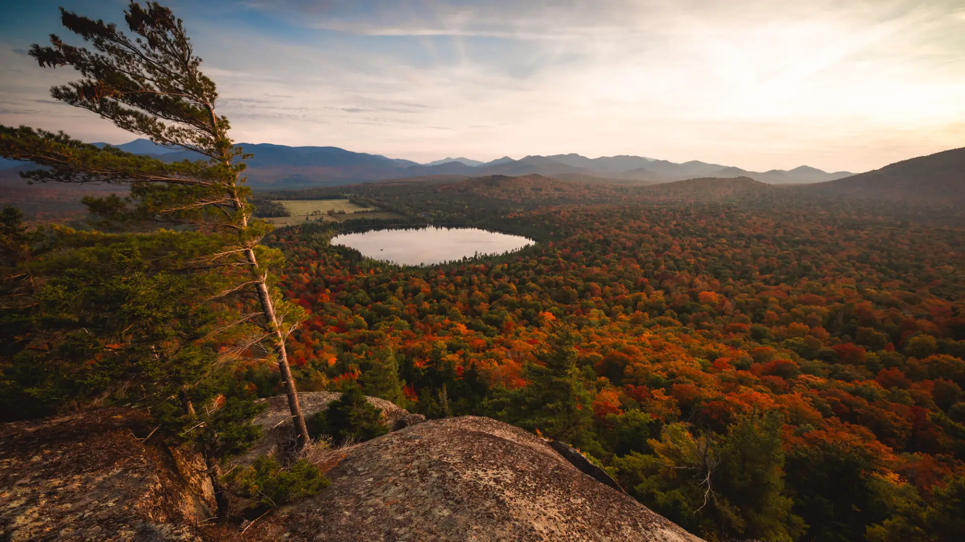 A scenic view point of surrounding foliage and lakes in the mountains. 