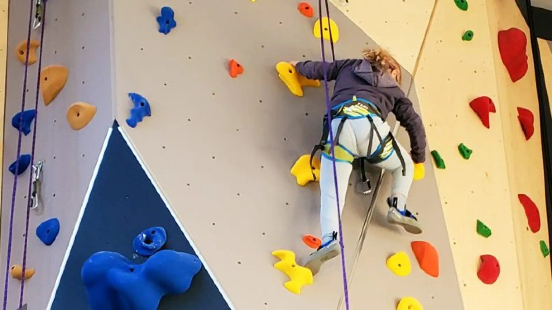 Climber nears the top of the climbing wall