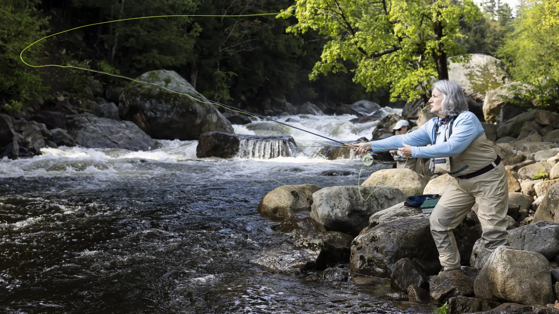 A fly fisher casting into a river