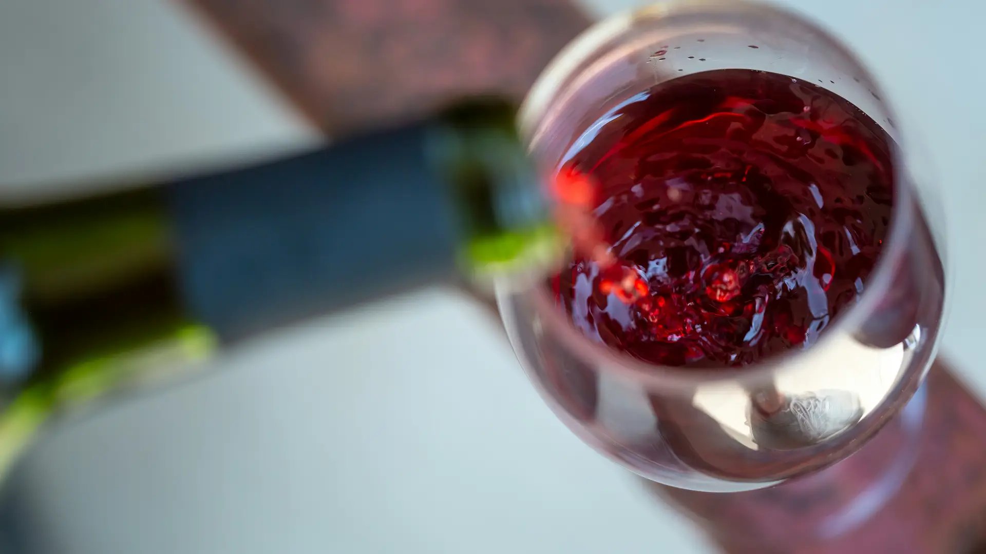 Stock image of red wine being poured from bottle to glass
