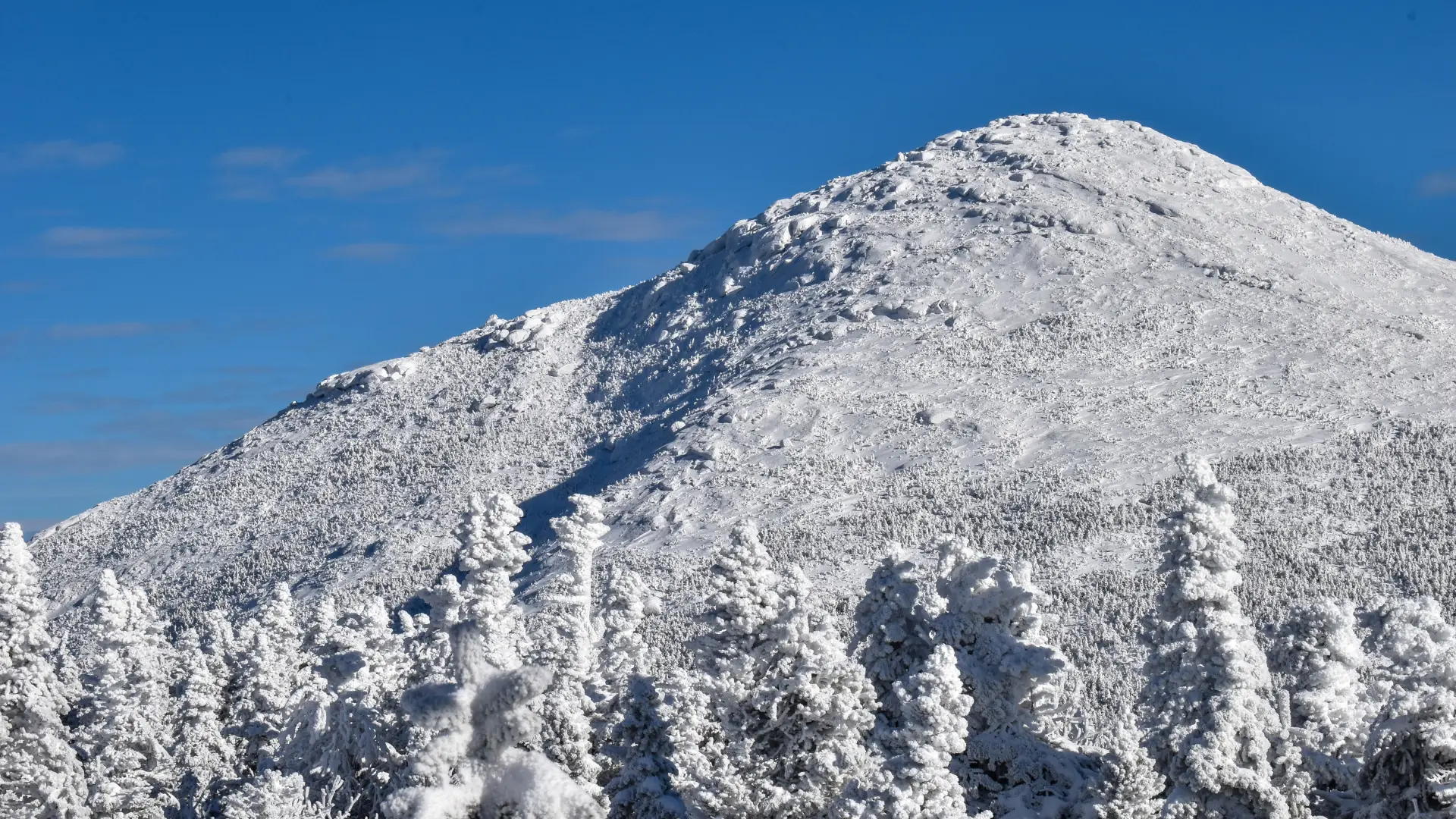 A large, domed, snow-capped peak